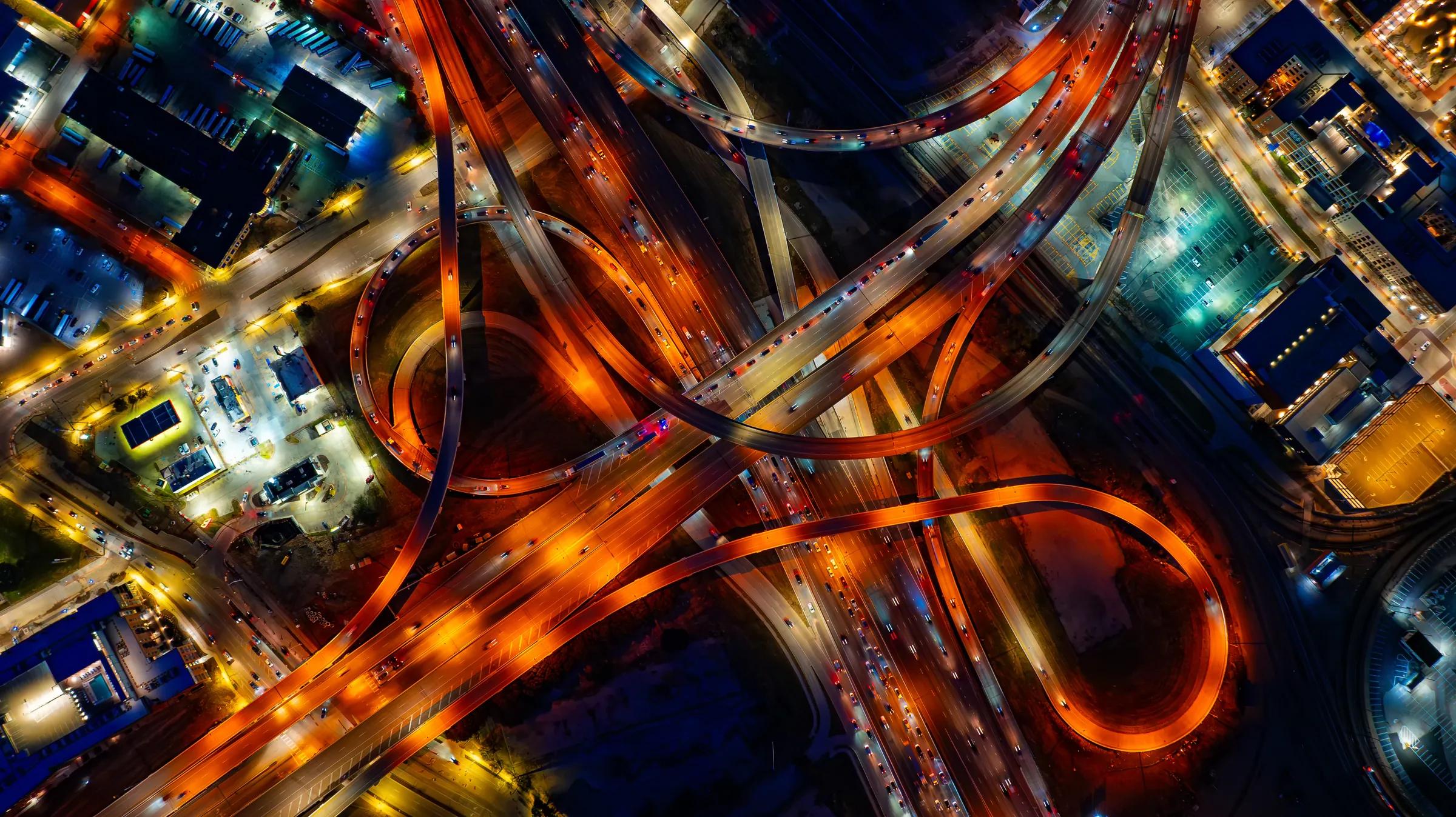 An overhead night view of a lit Dallas highway interchange