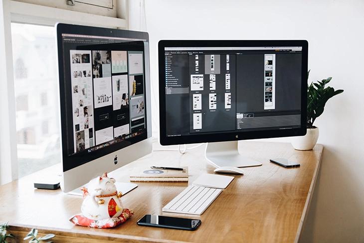 mulitple apple monitors running  website plan on the screen