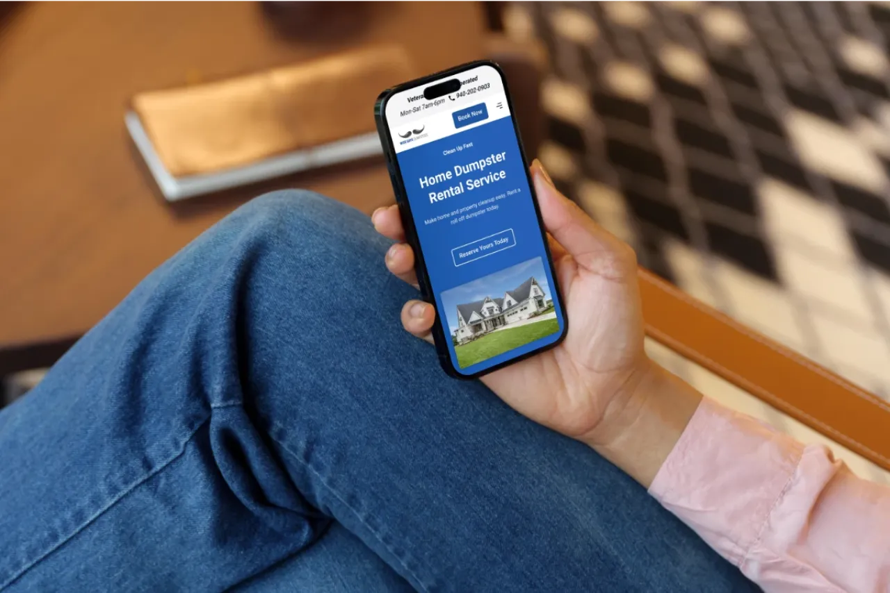Man holding a phone looking at Wise Guys Dumpsters on the screen