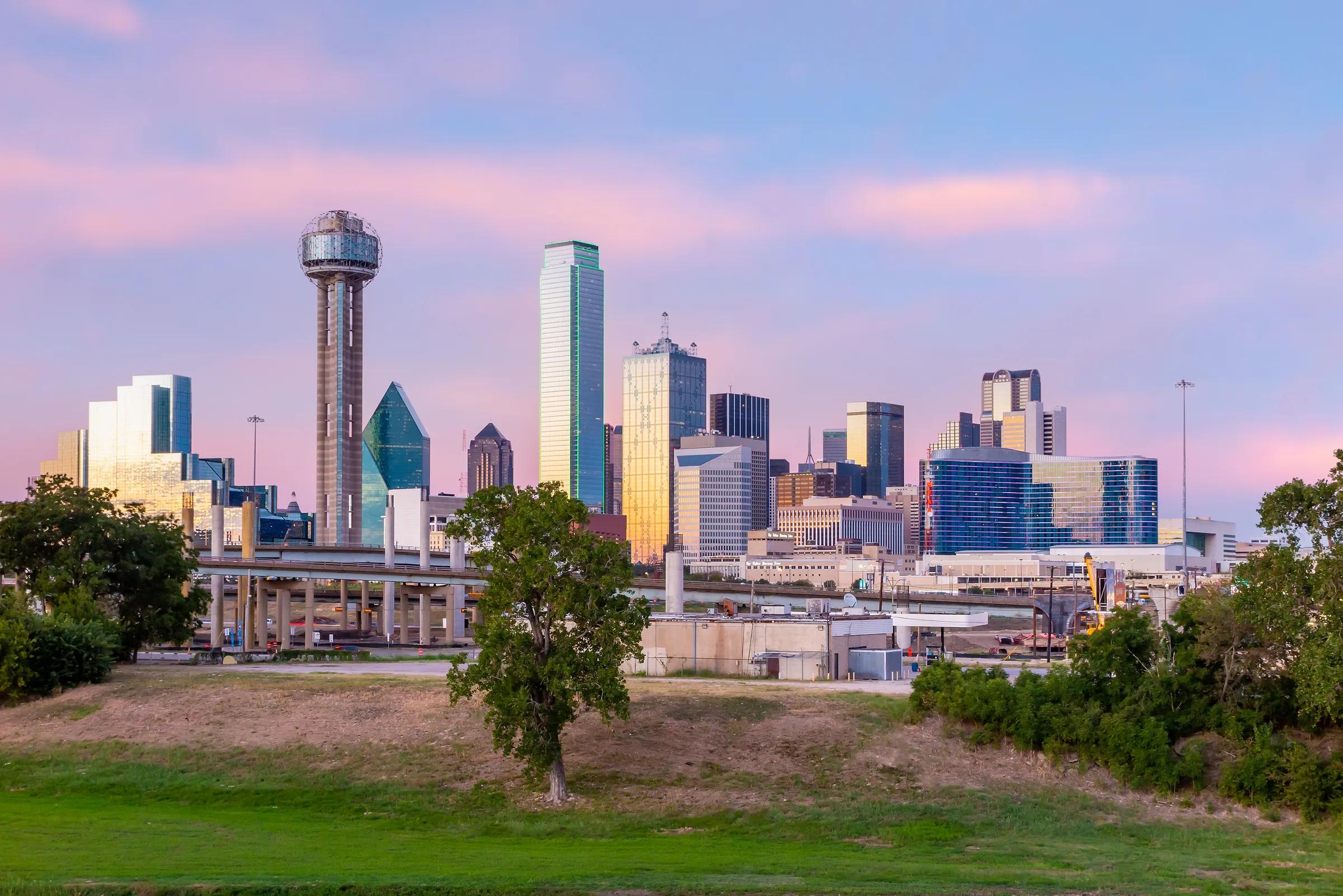 Reunion Tower and Downtown Dallas at dusk, seen across an open park