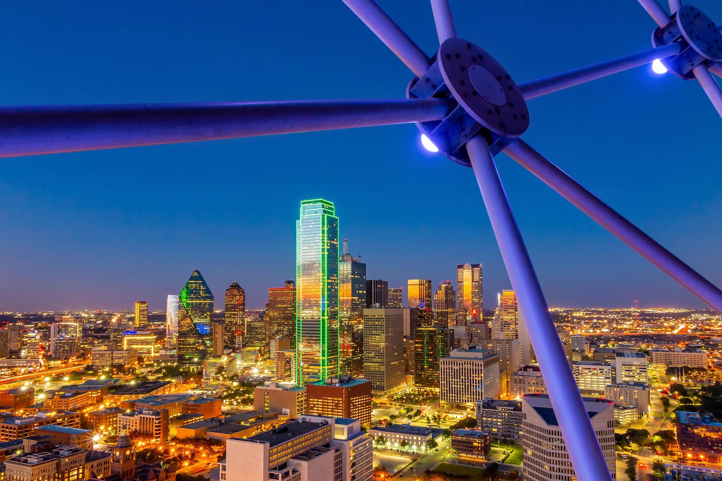 The Downtown Dallas skyline at dusk seen through the frame of Reunion Tower