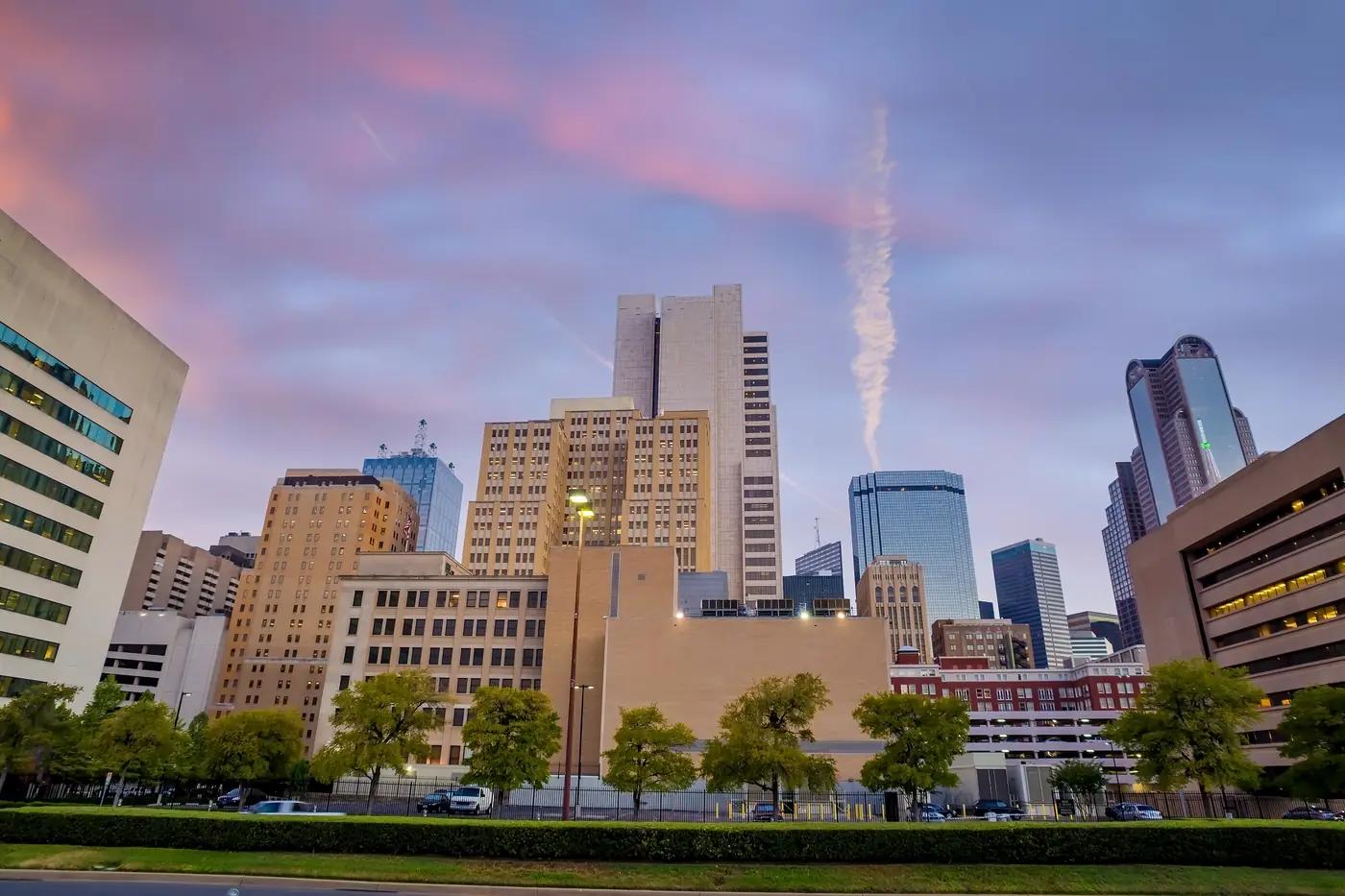 A North Texas downtown skyline at dusk under a pink sky