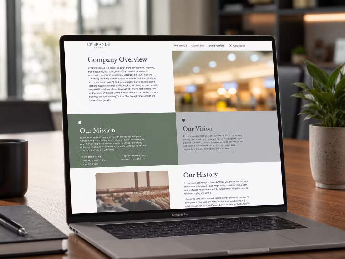 Laptop on a desk displaying the CP Brands Group website Company Overview page, with Our Mission, Our Vision, and Our History sections.