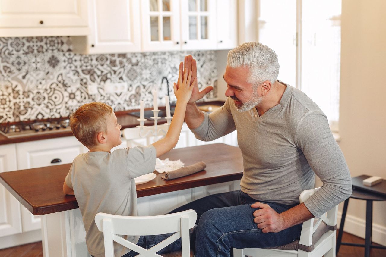 Parent présentant à un enfant un petit menu de récompenses non monétaires après une corvée