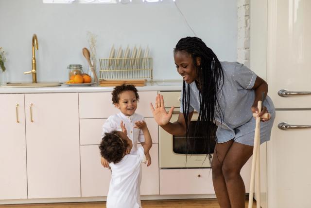 Une mère et ses deux enfants partagent un moment complice et détendu en cuisine