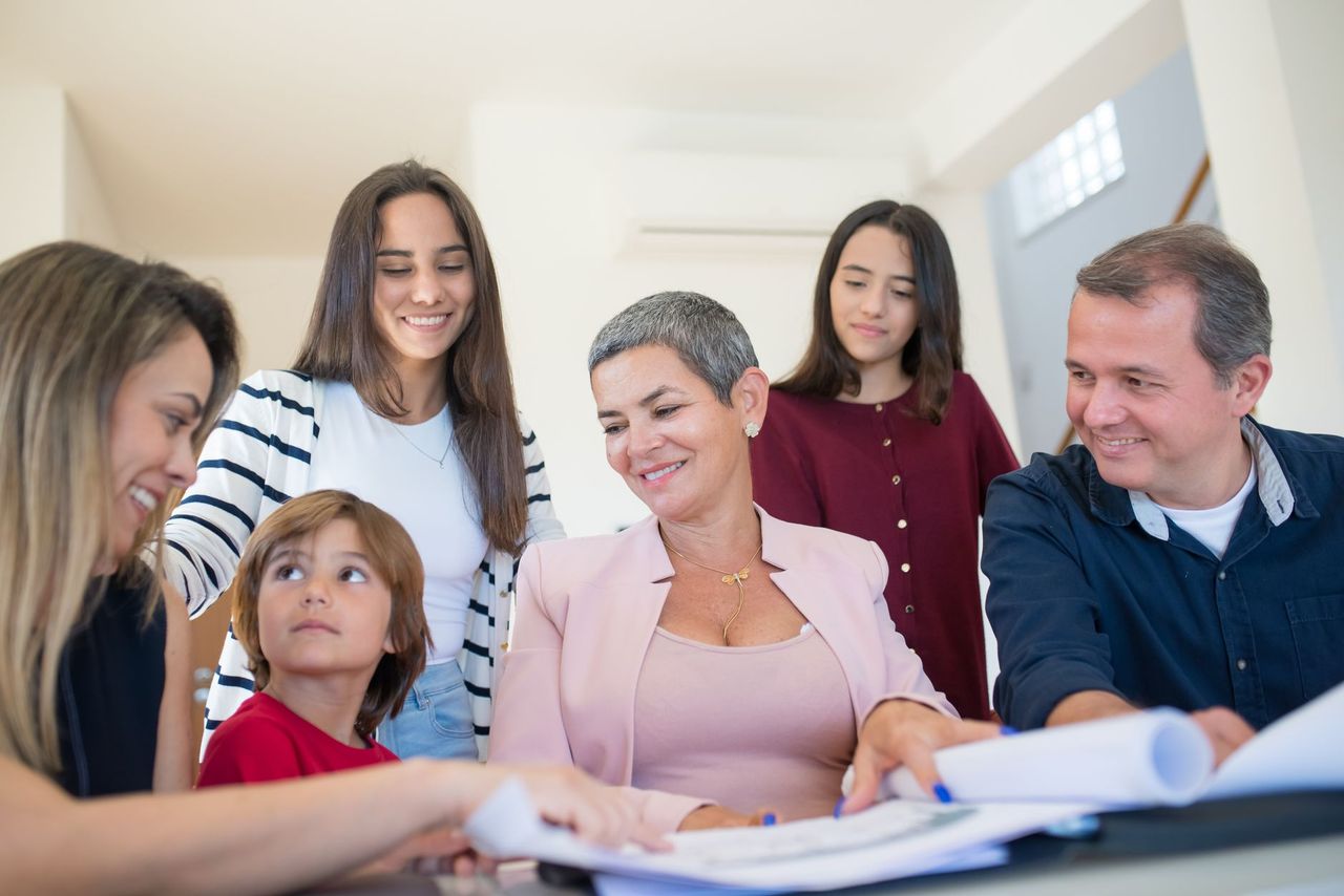 Parent and child filling in a screen time agreement at a kitchen table