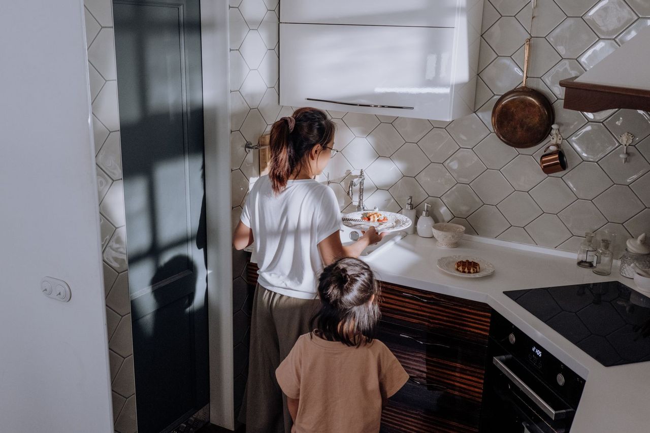Tween placing folded clothes into drawers while following a simple household checklist
