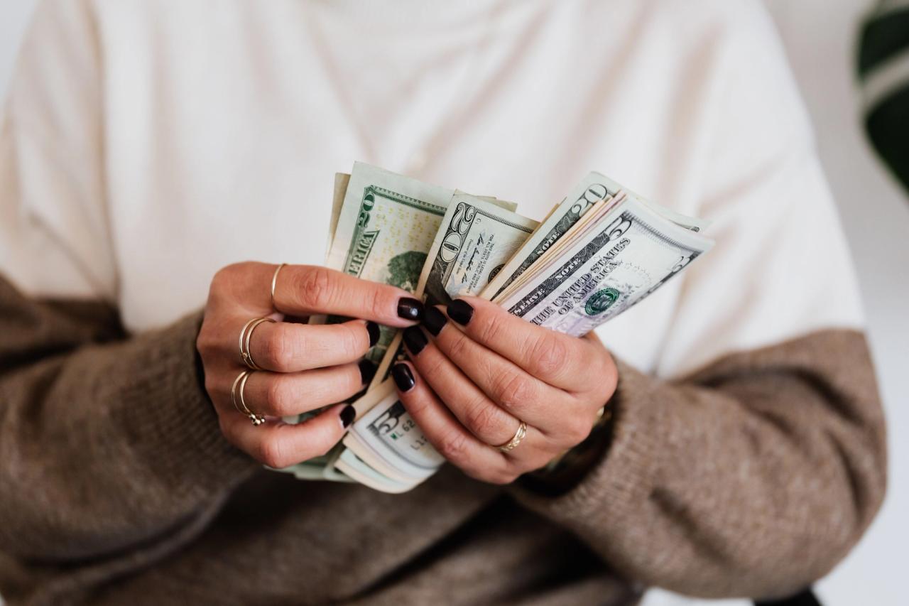 Des mains comptent plusieurs billets de banque