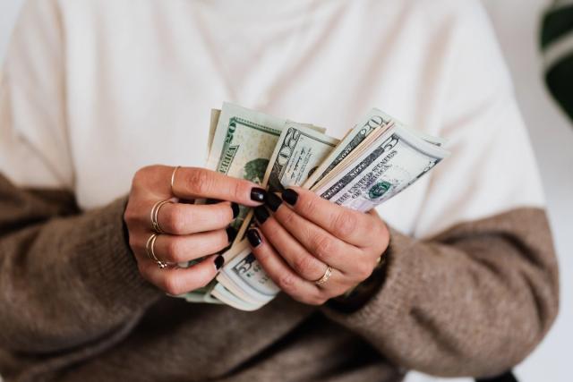 Des mains comptent plusieurs billets de banque
