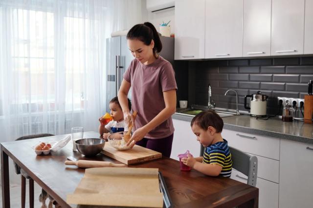 Siblings and a parent reviewing a household chore chart together