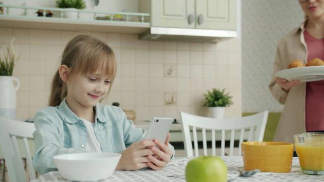 Parent and child reviewing a signed screen time contract beside a charging station
