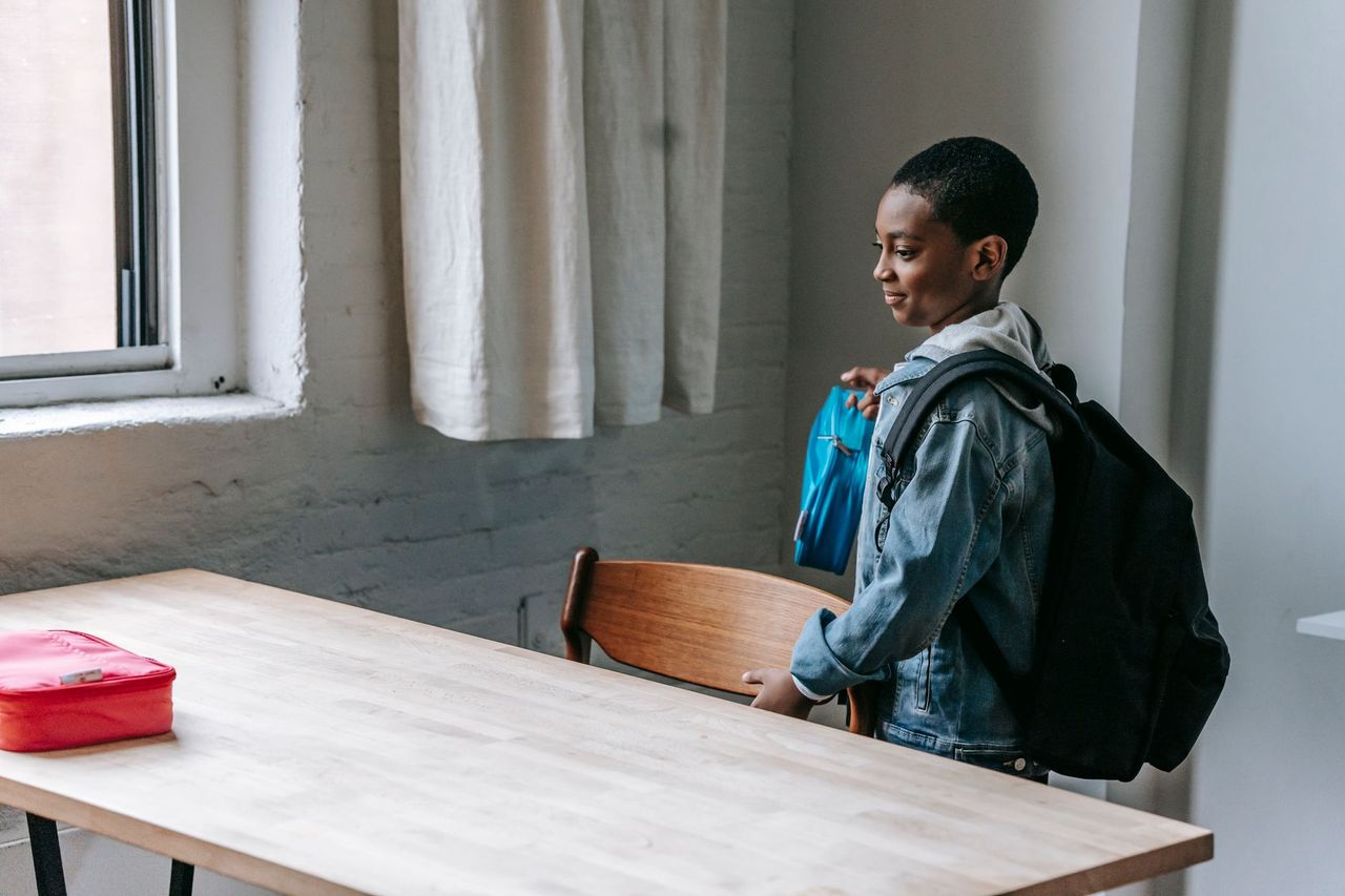 Child following a simple after-school chore routine by putting belongings away at home