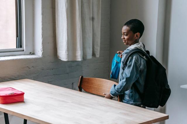 Child following a simple after-school chore routine by putting belongings away at home