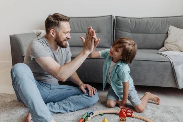 Parent et enfant qui se felicitent apres un objectif atteint sur le tableau de recompense