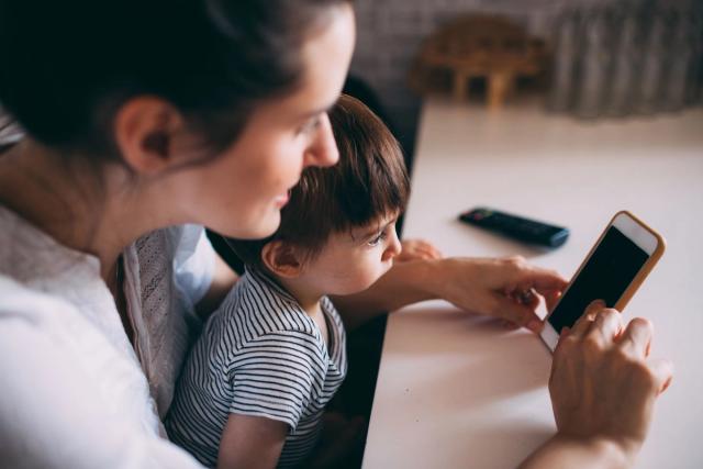Parent and child comparing family organisation apps on a tablet and smartphone