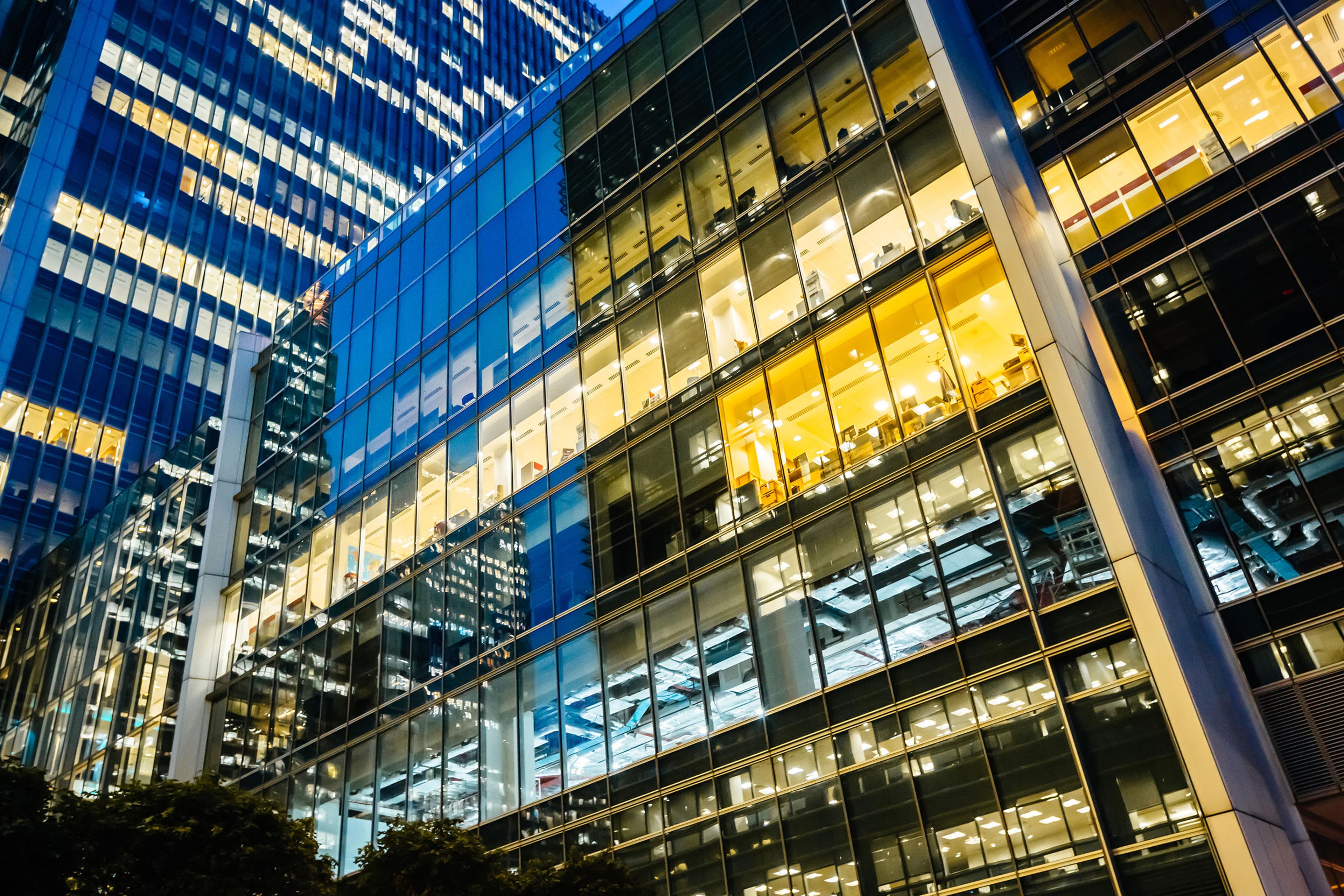 a tall building with lots of windows is lit up at night .