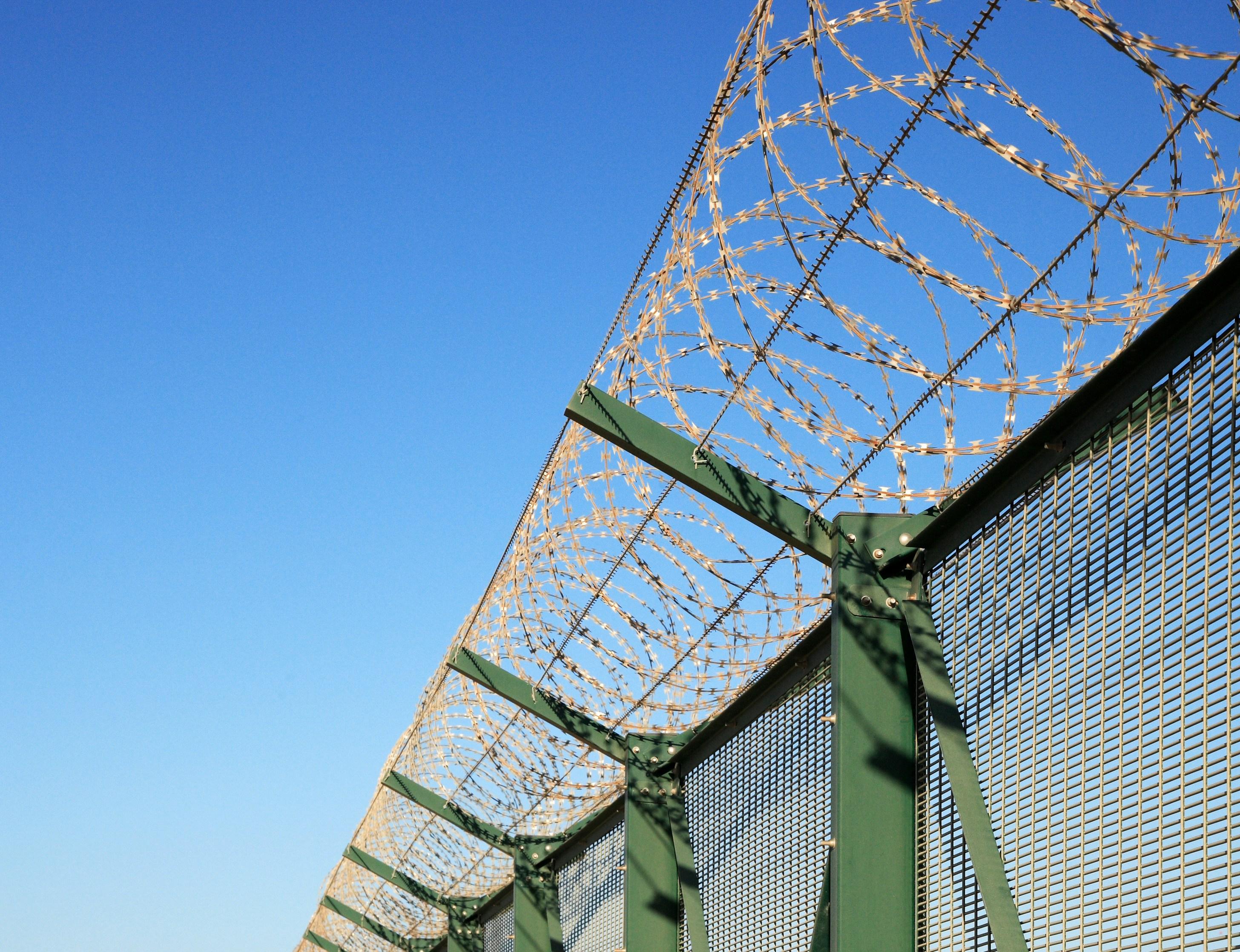 a barbed wire fence with a blue sky in the background .