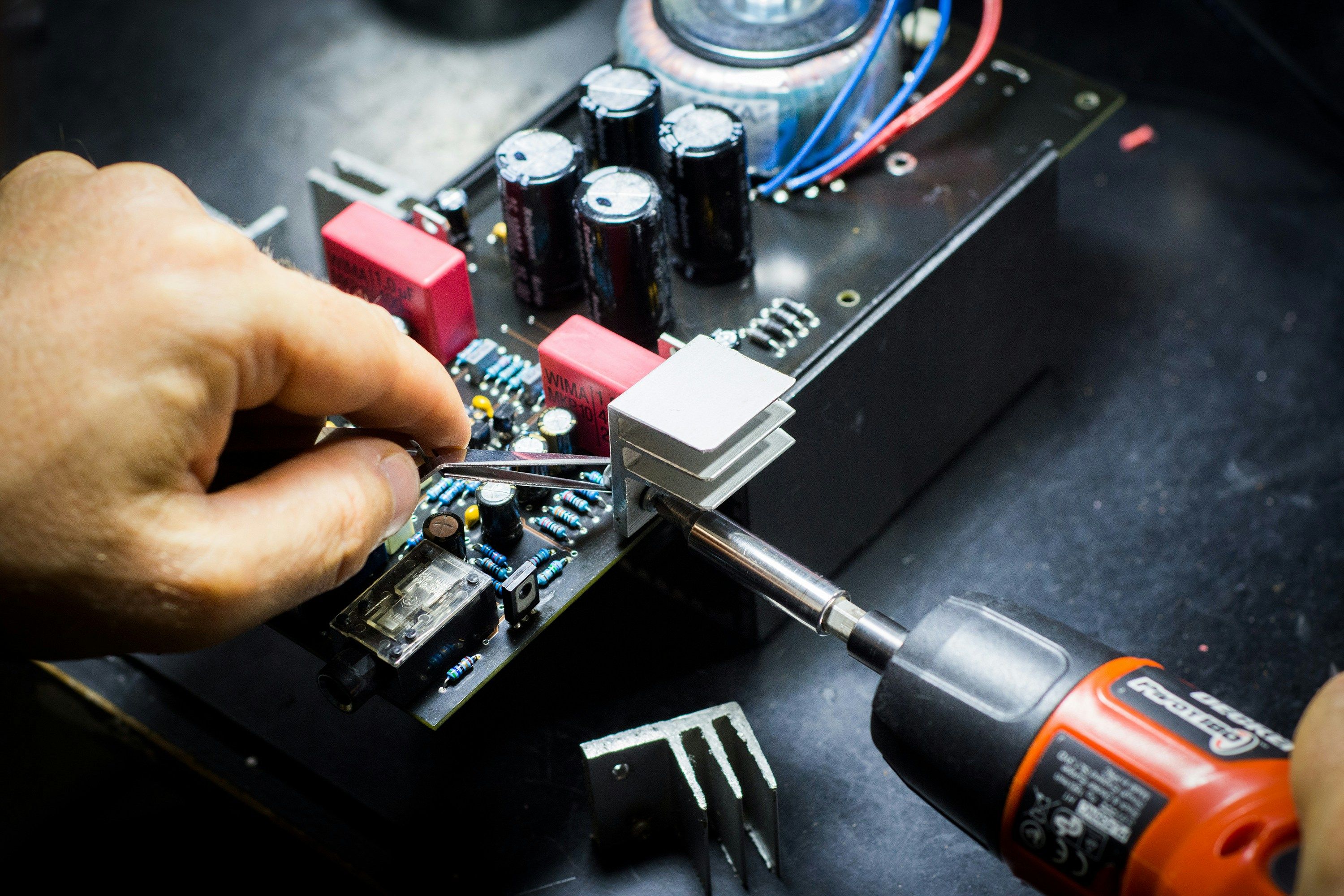 a person is working on a motherboard with a screwdriver .