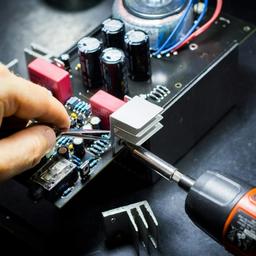 a person is working on a motherboard with a screwdriver .
