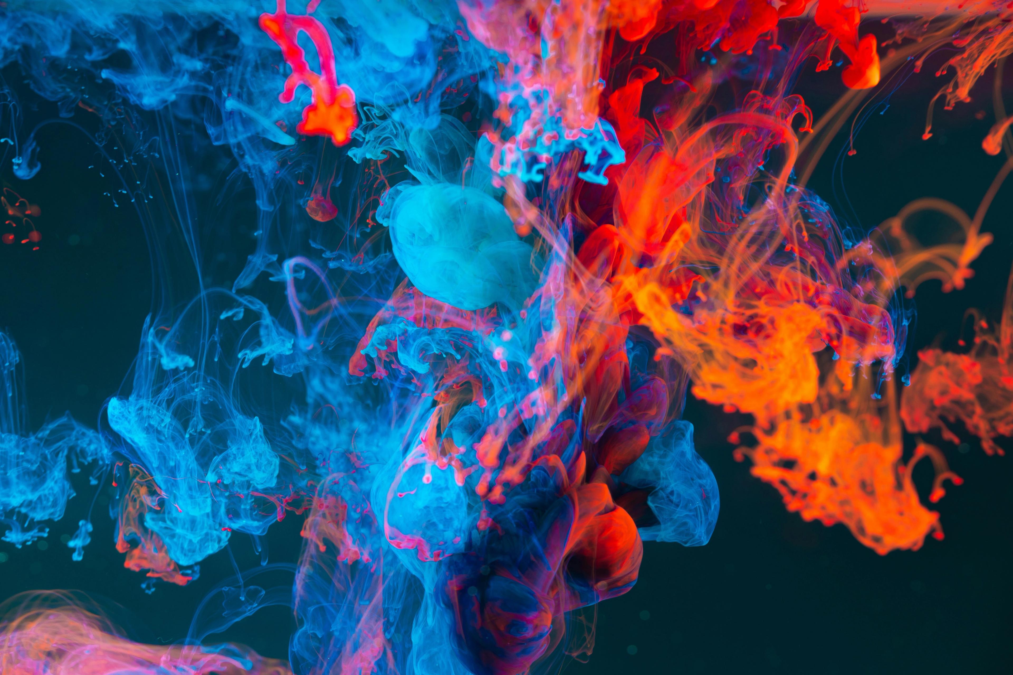 a bunch of colorful smoke is coming out of the water .
