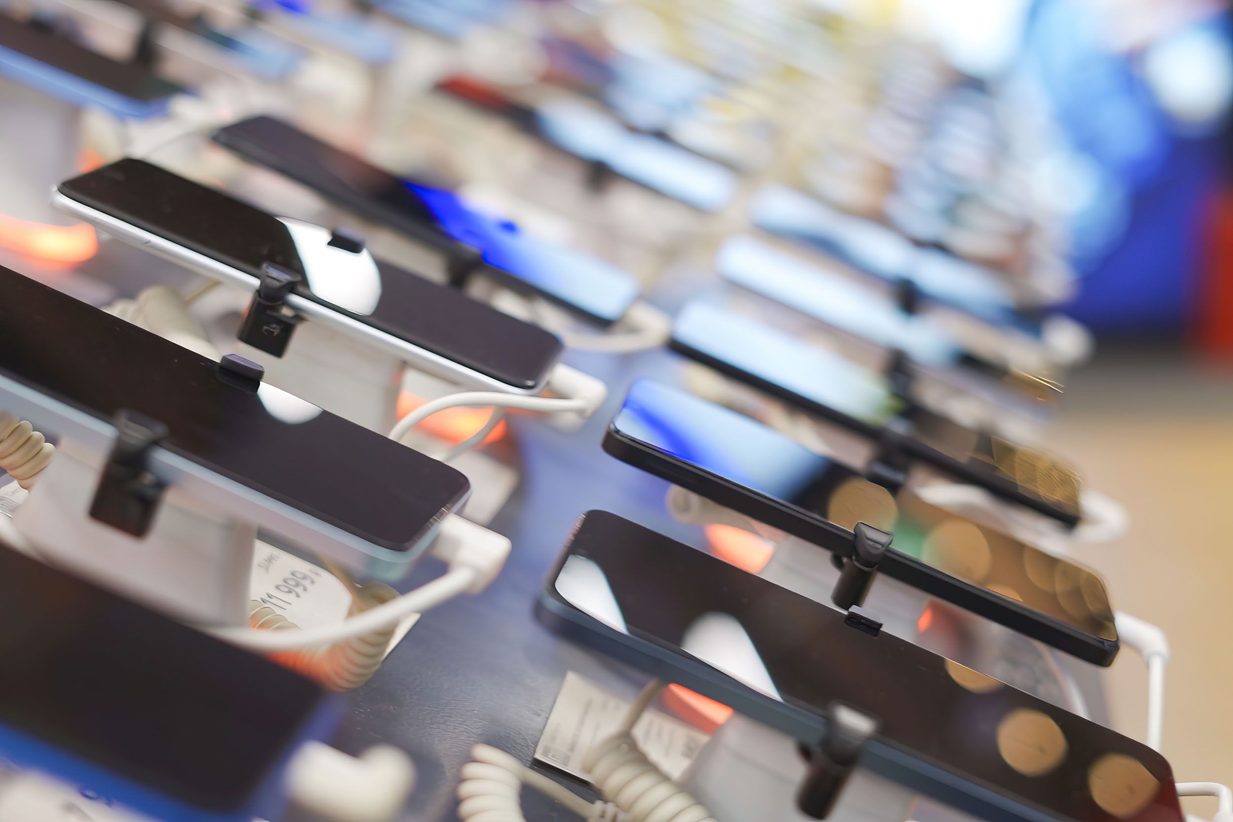 a row of cell phones sitting on display in a store .