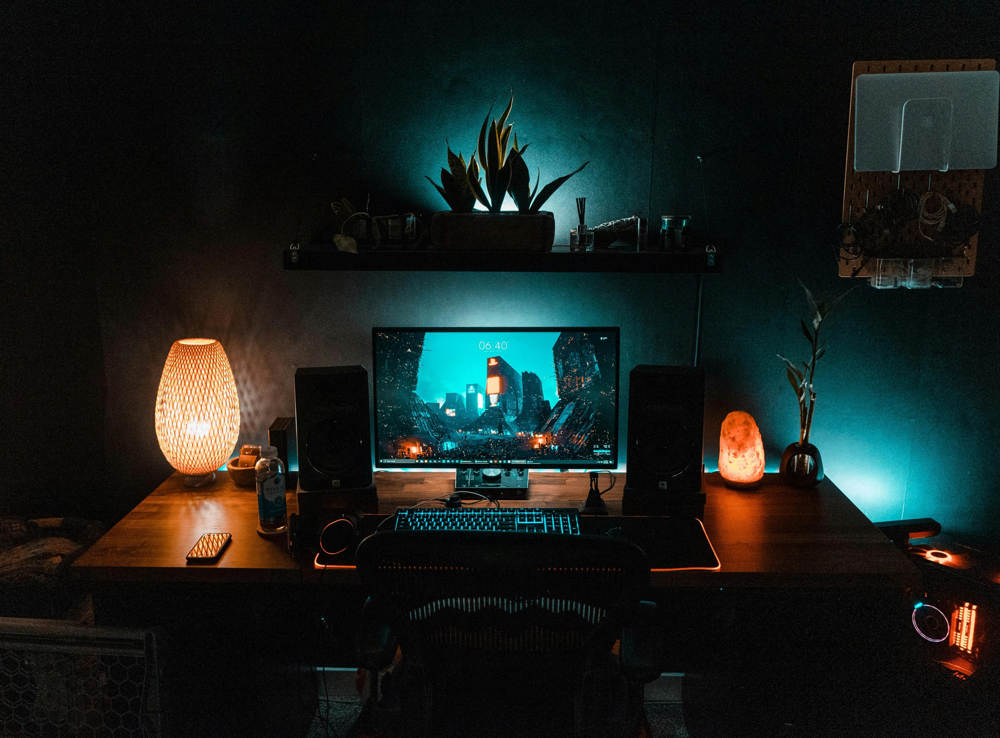 a computer is sitting on top of a wooden desk in a dark room .
