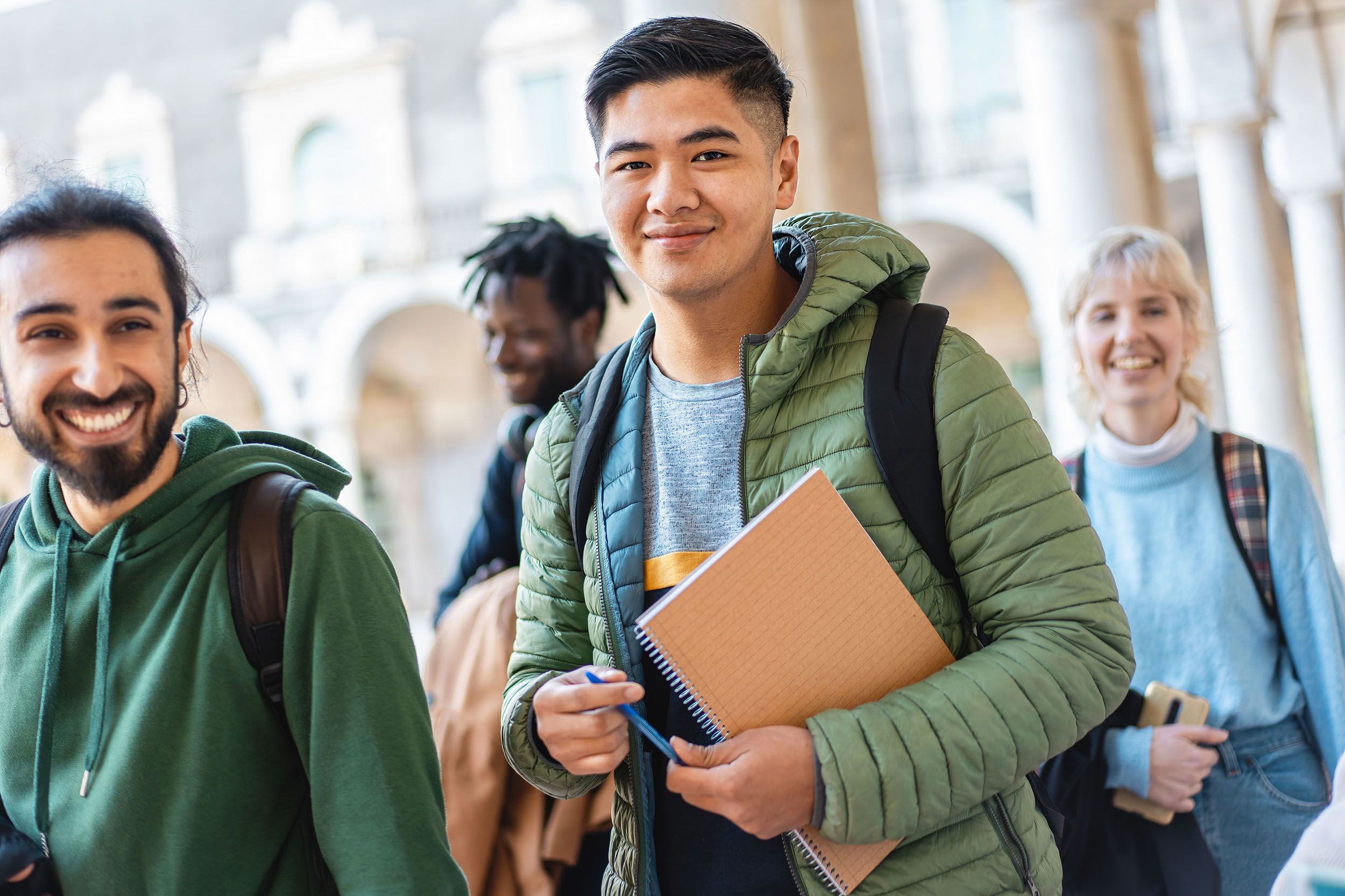 a group of students are standing next to each other in a hallway .