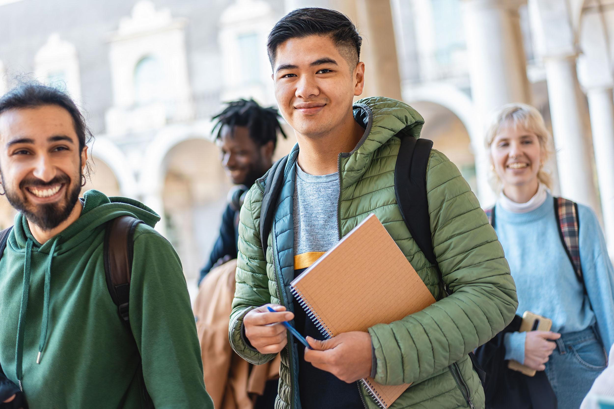 a group of students are standing next to each other in a hallway .