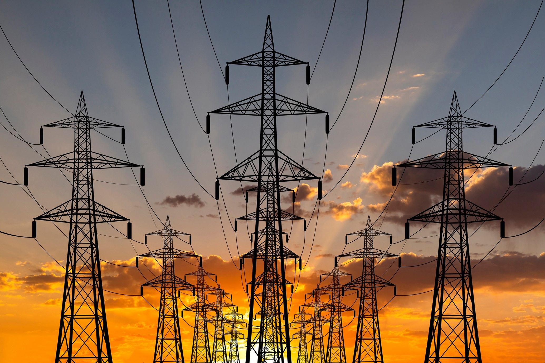 a row of power lines against a sunset sky .