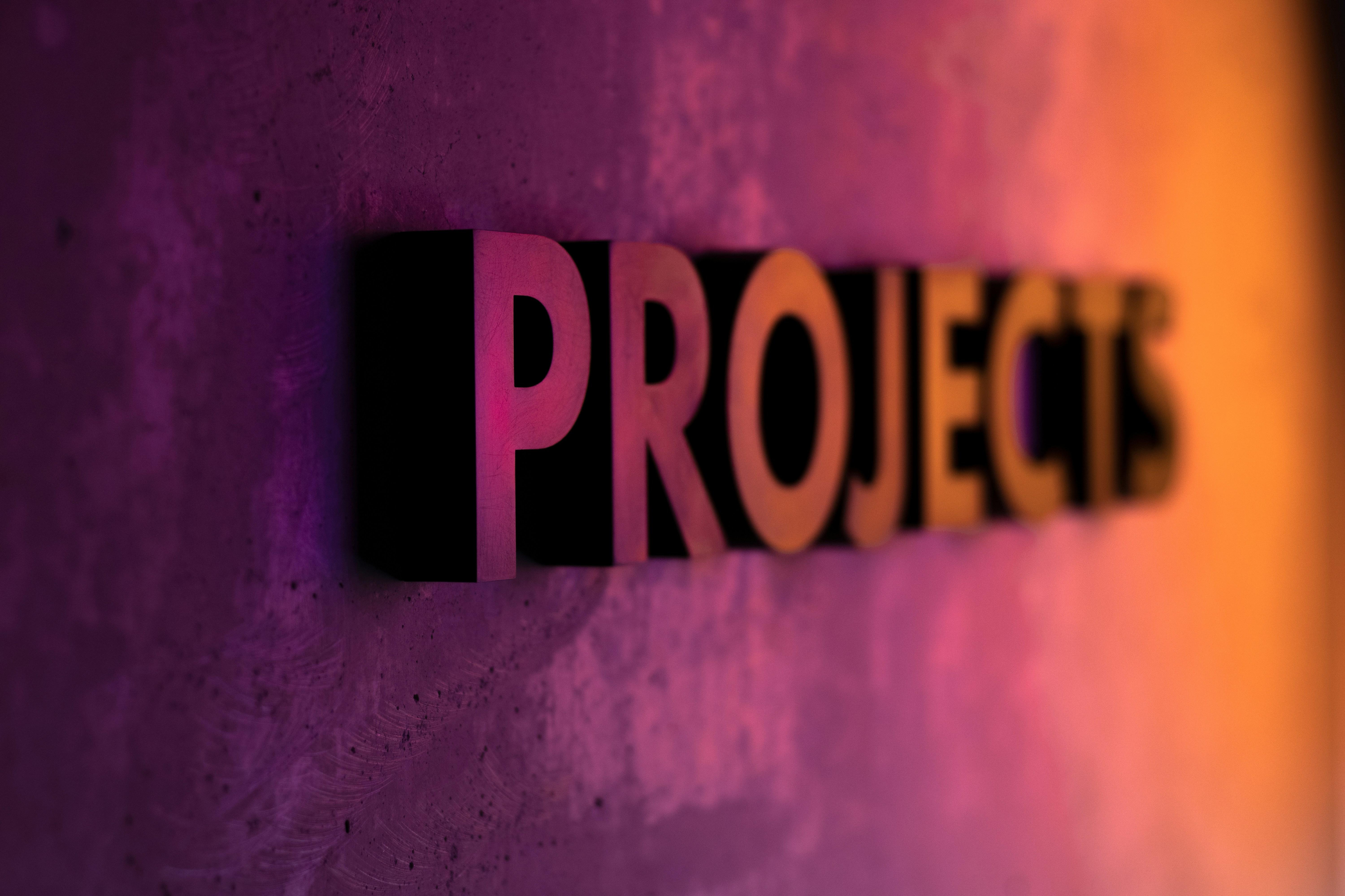 the word projects is on a purple and orange wall .