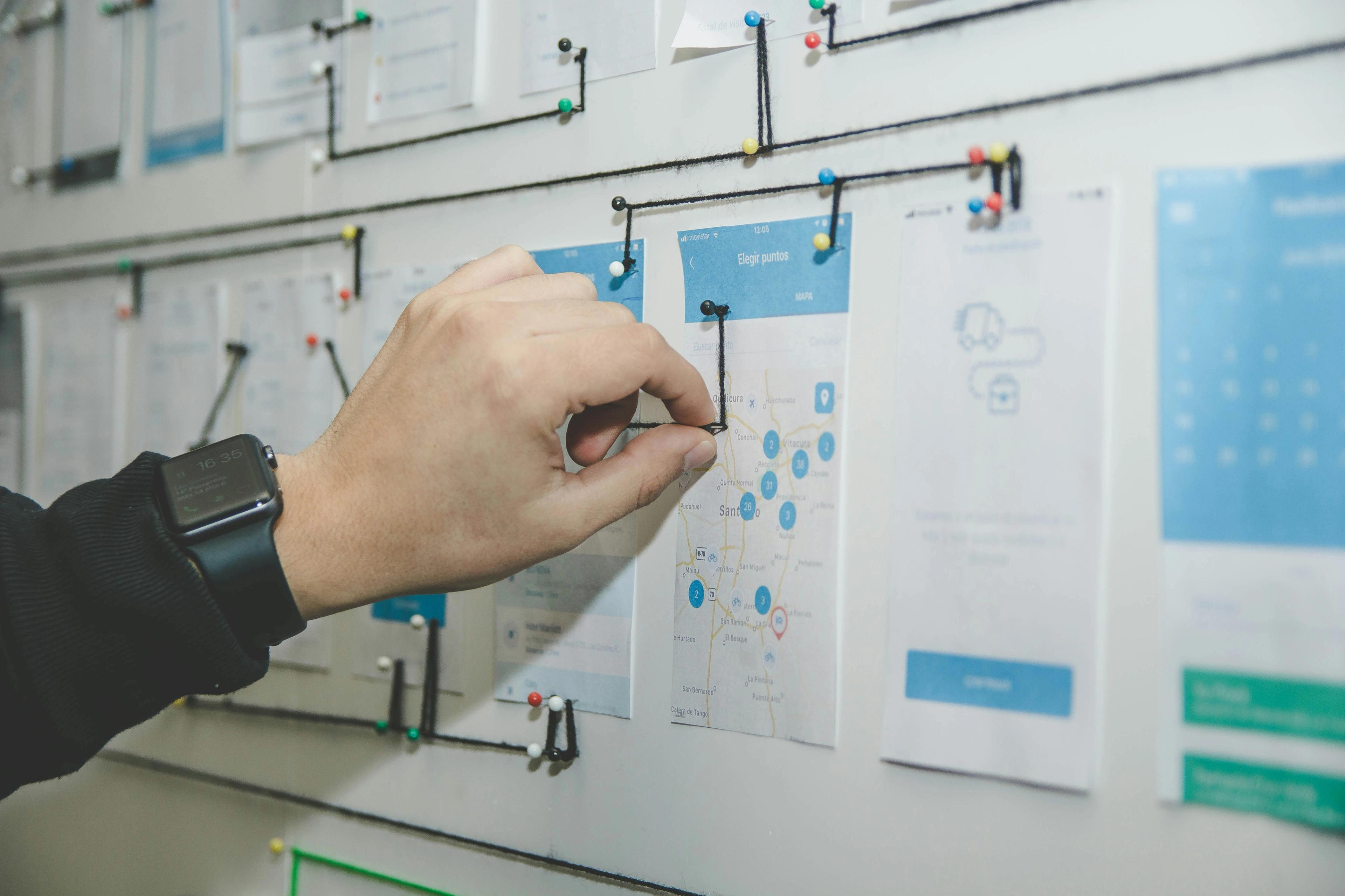 a person is pinning a diagram on a whiteboard .