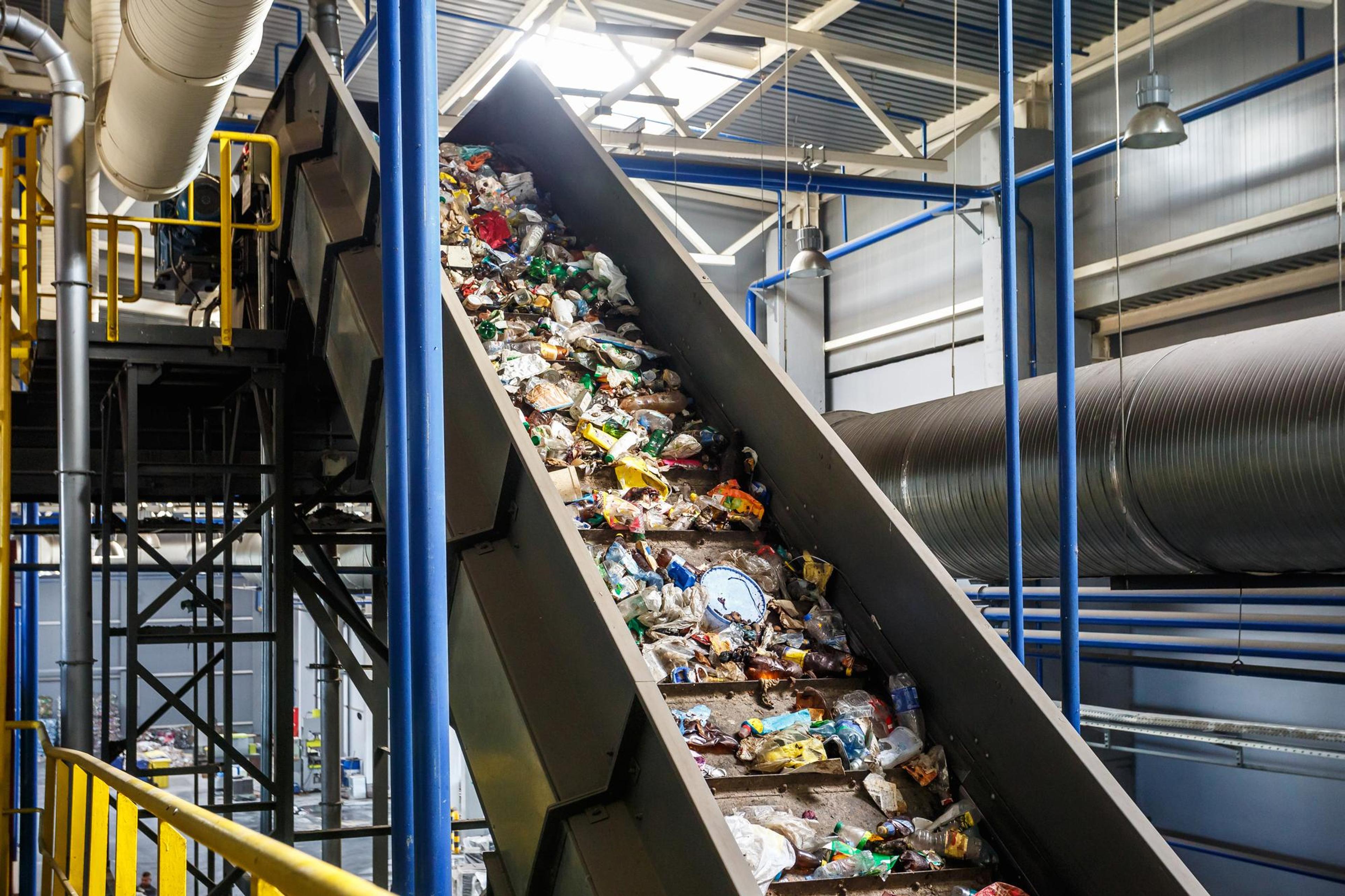 a conveyor belt filled with garbage in a factory .
