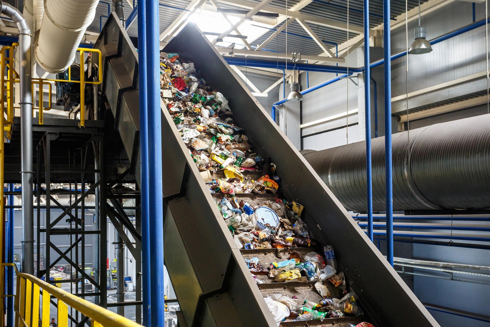 a conveyor belt filled with garbage in a factory .