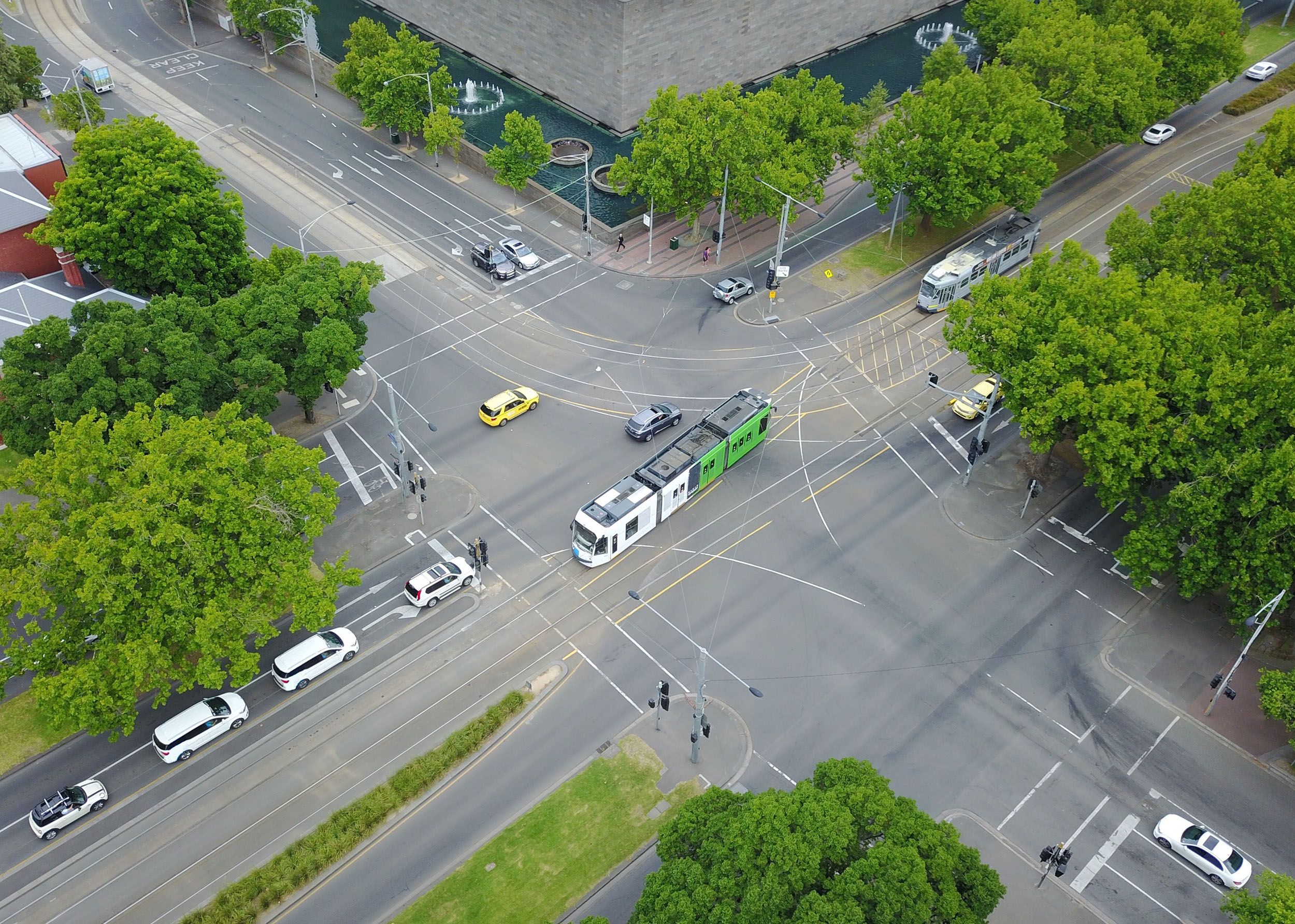 an aerial view of a busy intersection in a city filled with cars and trees .