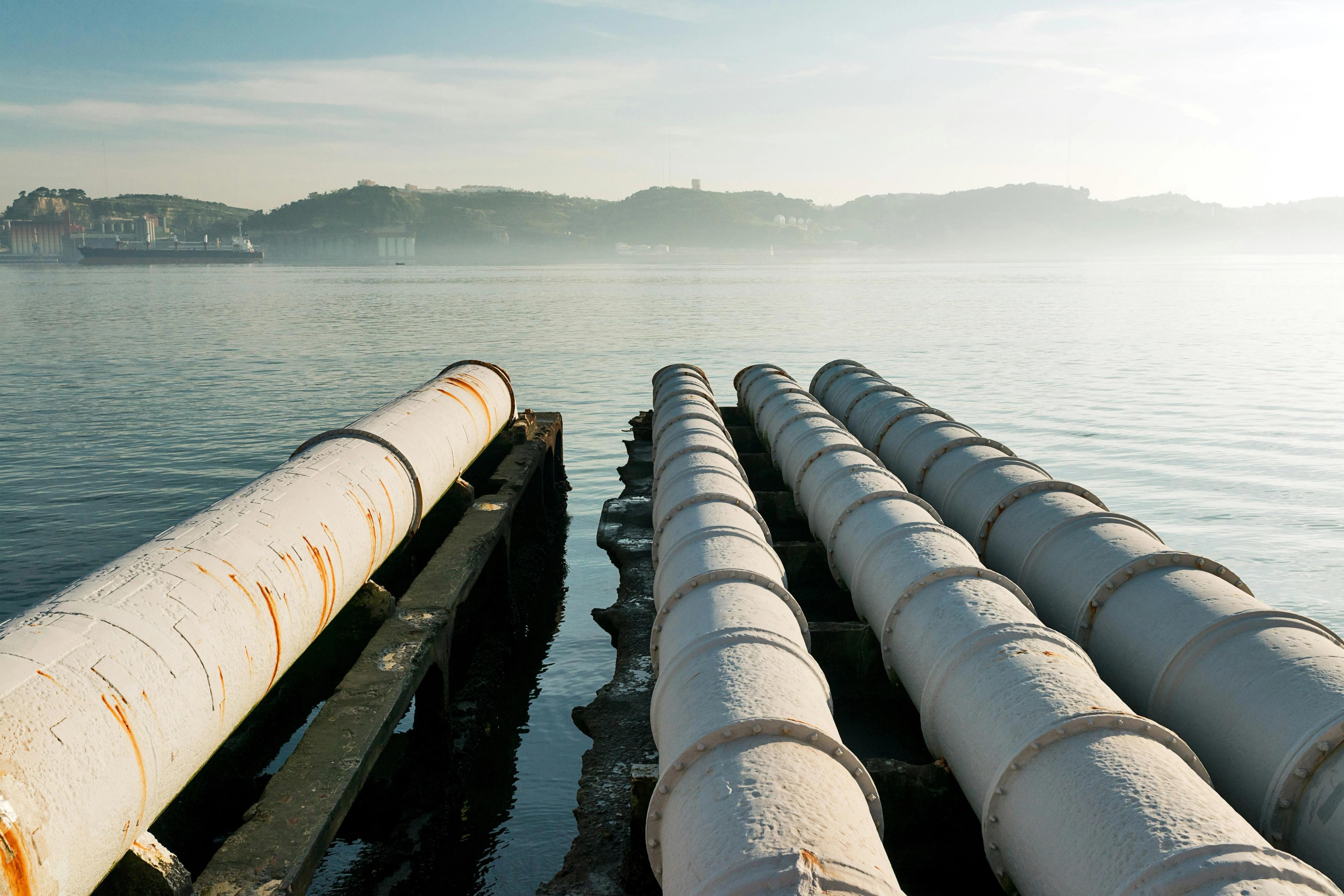 a row of pipes going into a body of water .