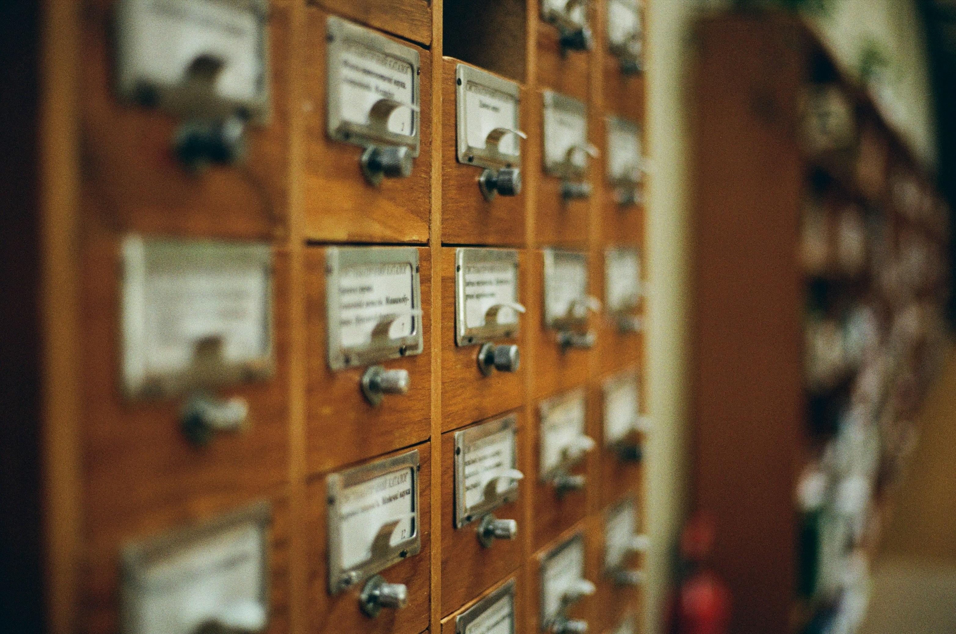 a row of wooden drawers with labels on them in a library .