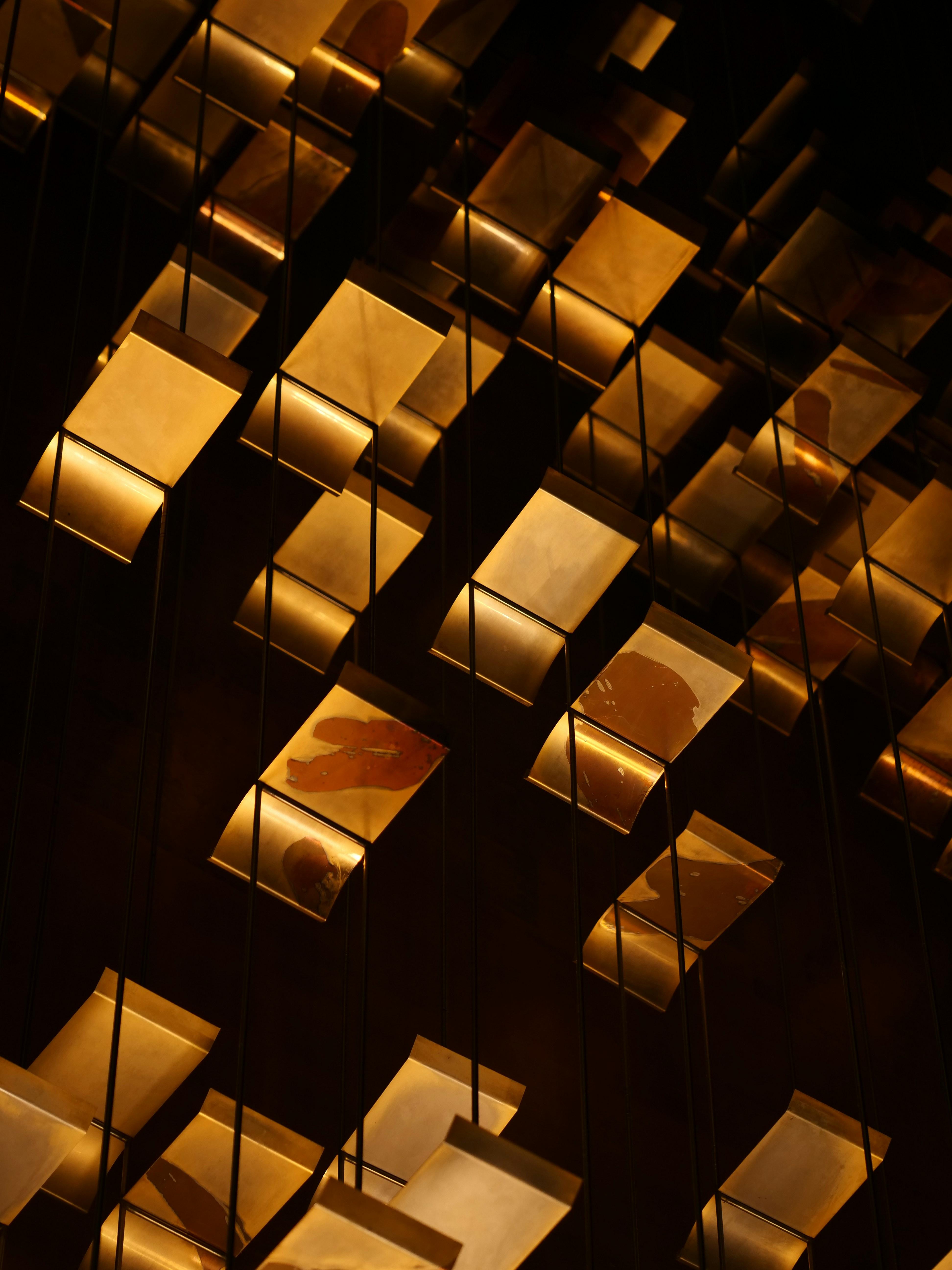 a bunch of gold squares are hanging from the ceiling