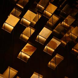 a bunch of gold squares are hanging from the ceiling