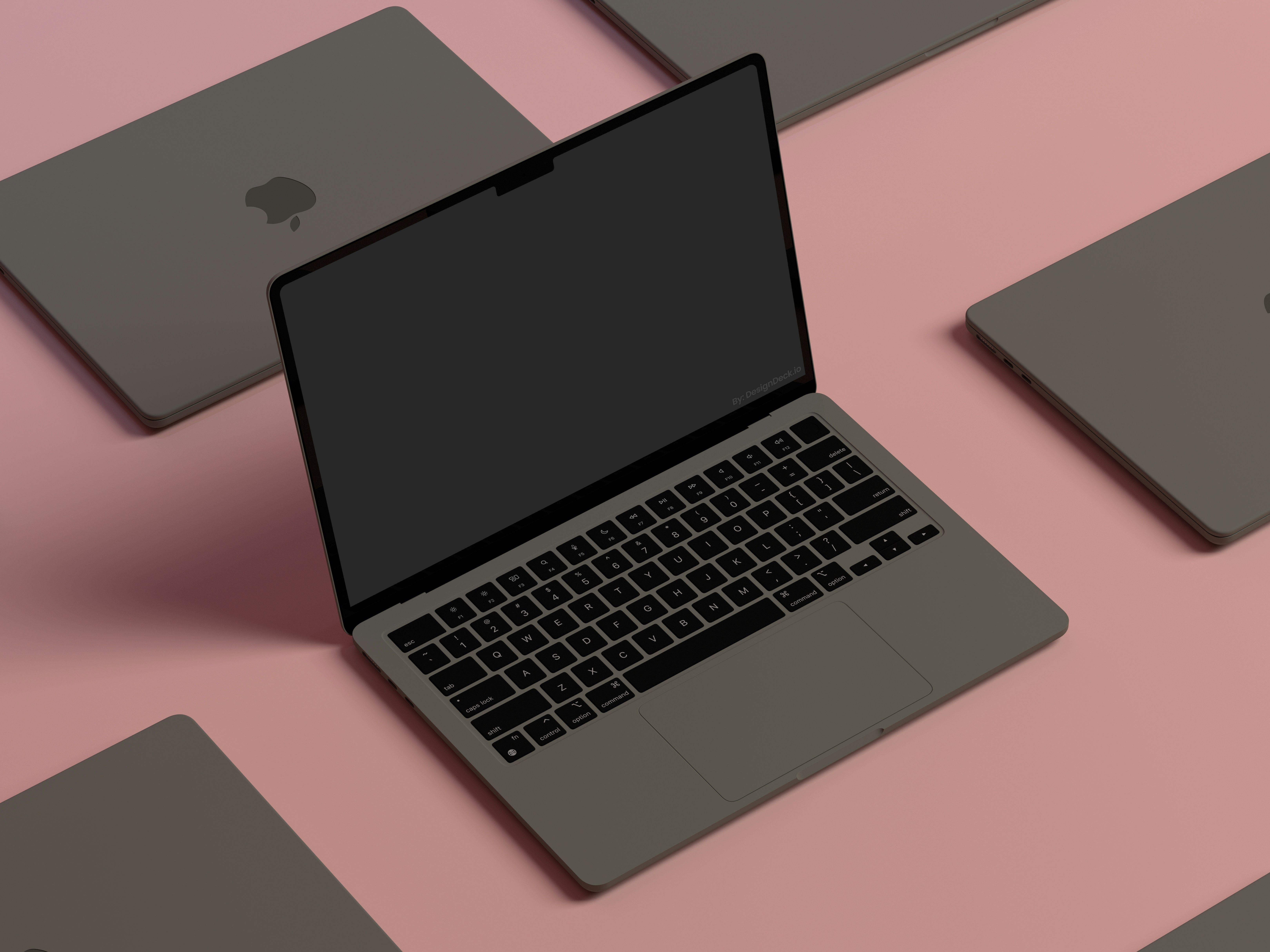 a group of laptops are sitting on top of each other on a pink surface .