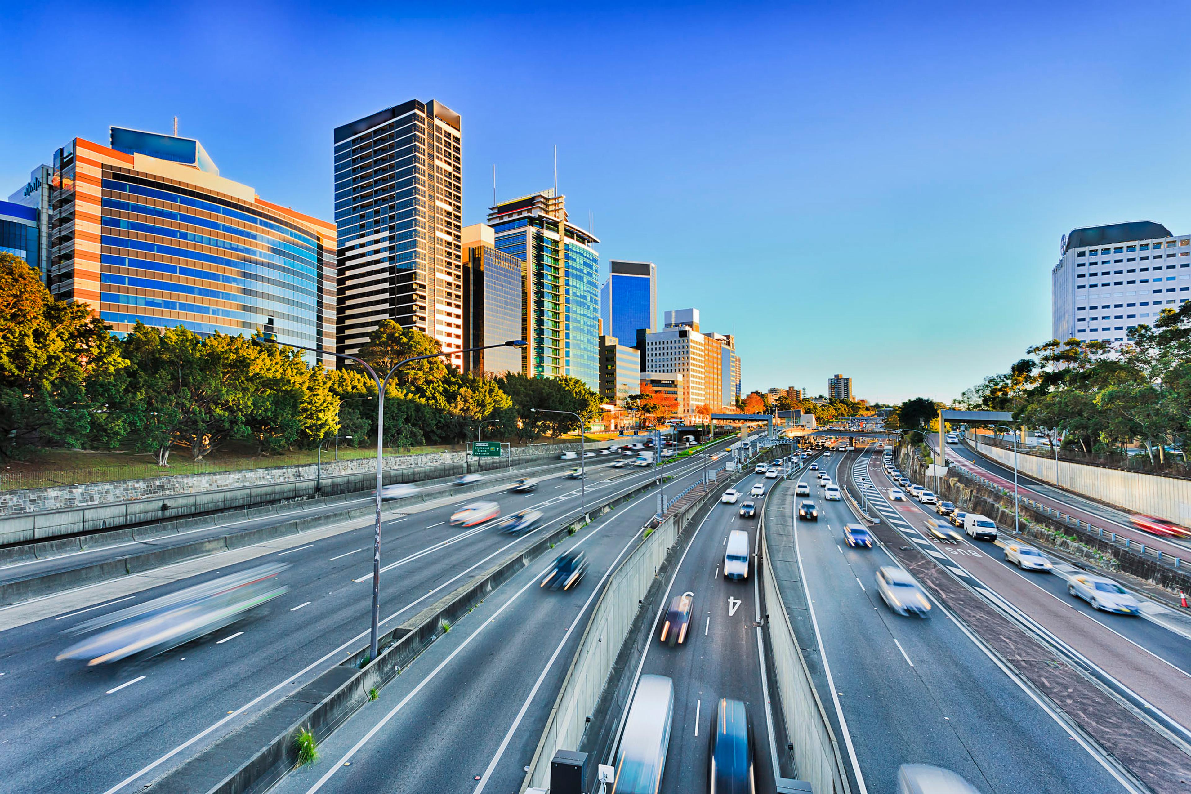 a highway in a city with a lot of traffic and buildings in the background .