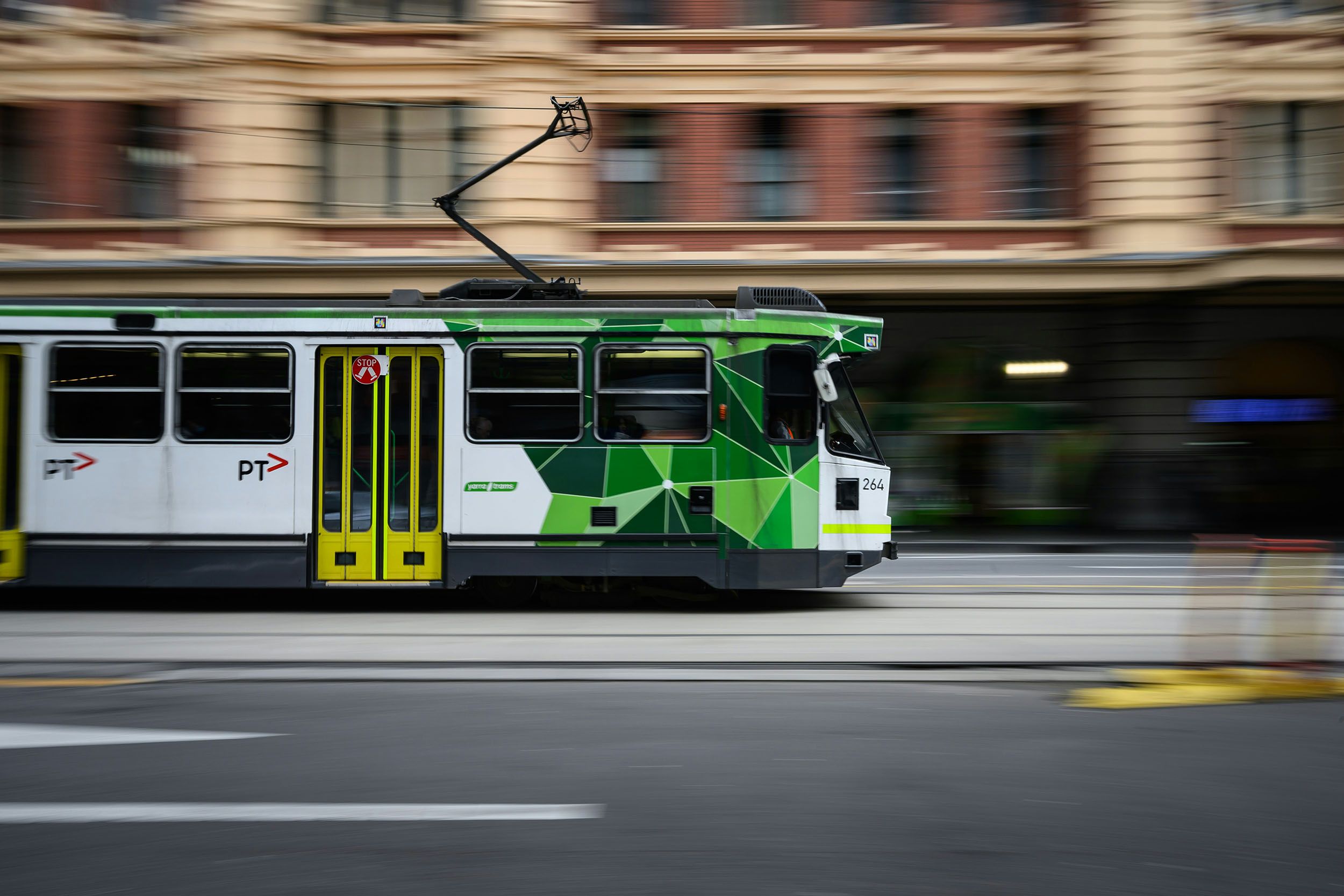 a trolley is driving down a city street .