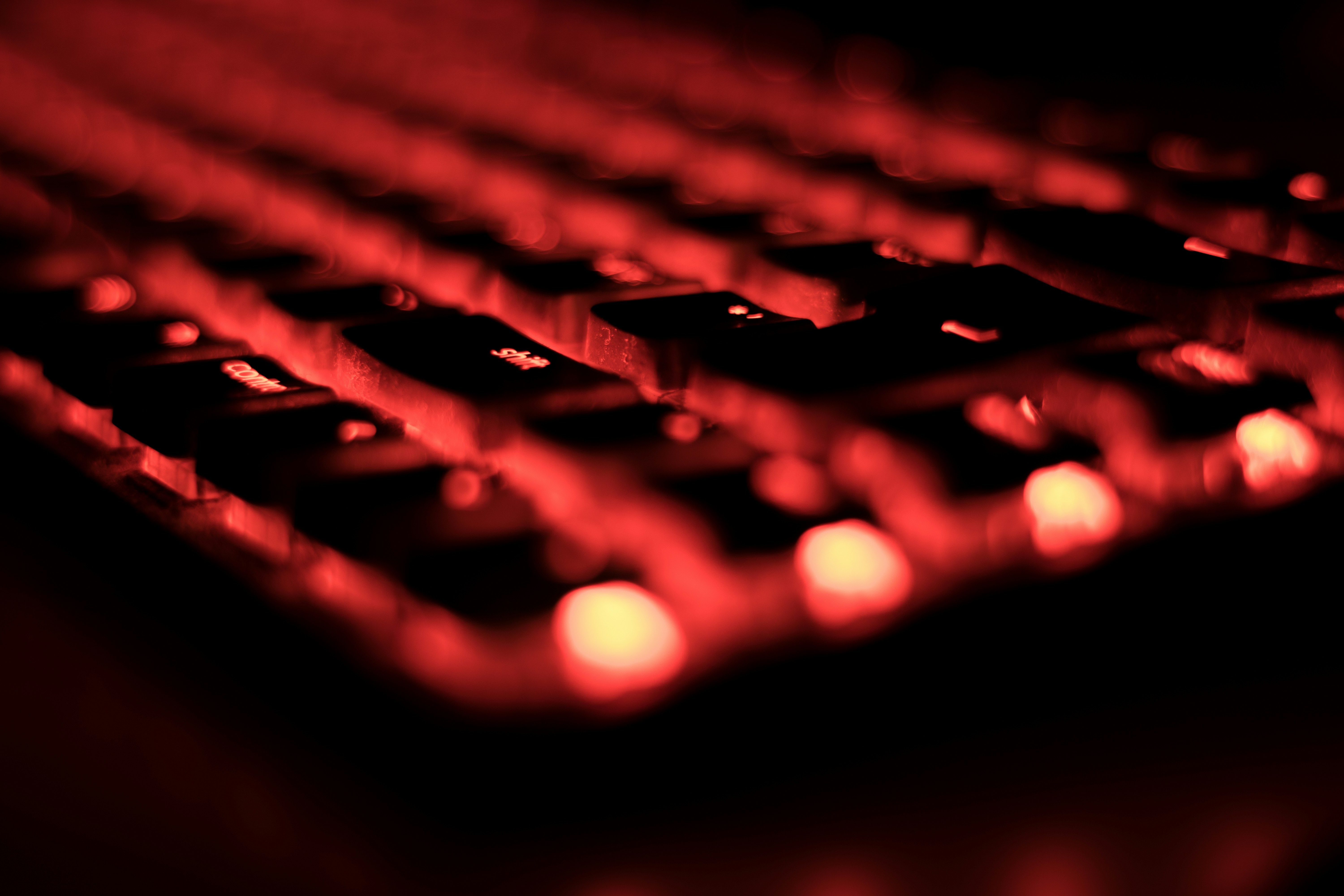 a close up of a computer keyboard with red lights on it .