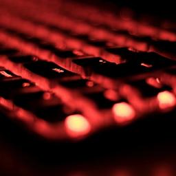 a close up of a computer keyboard with red lights on it .