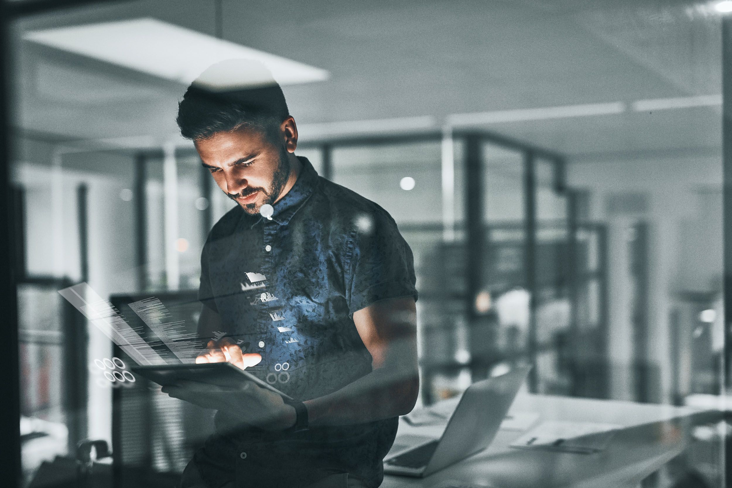 a man is looking at a tablet in an office .