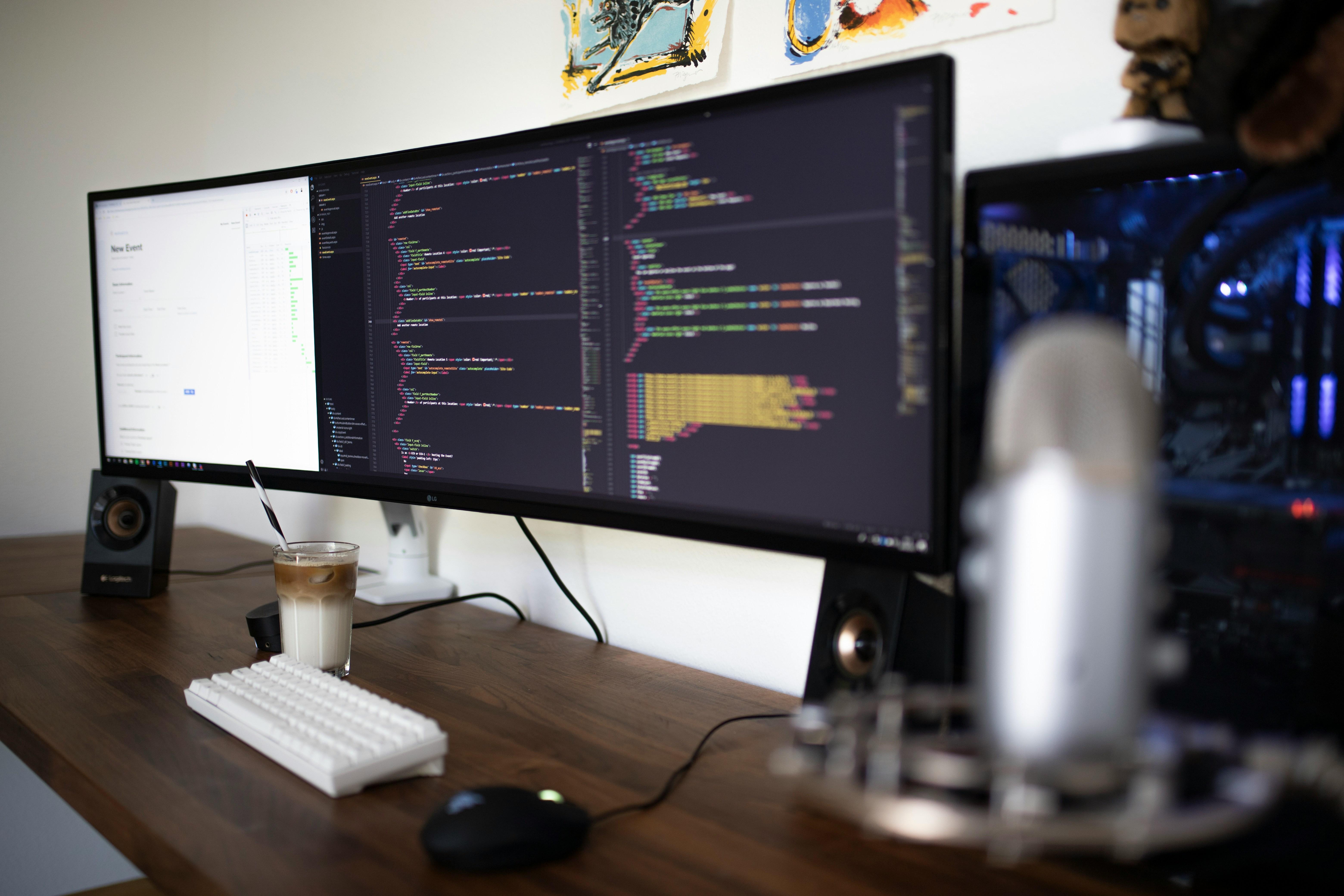 a computer desk with three monitors , a keyboard , a mouse and a cup of coffee .