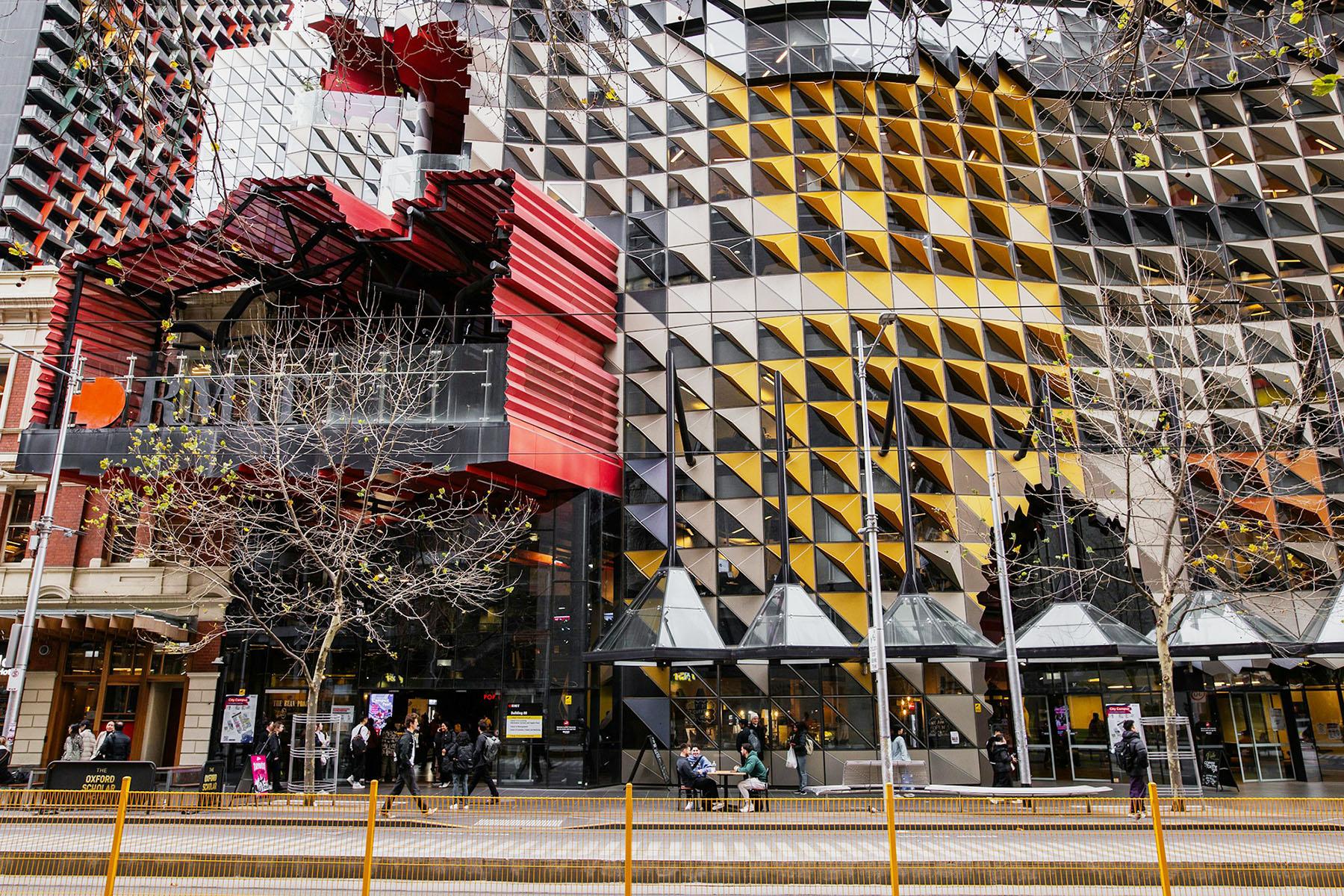 a group of people are walking in front of a large building .