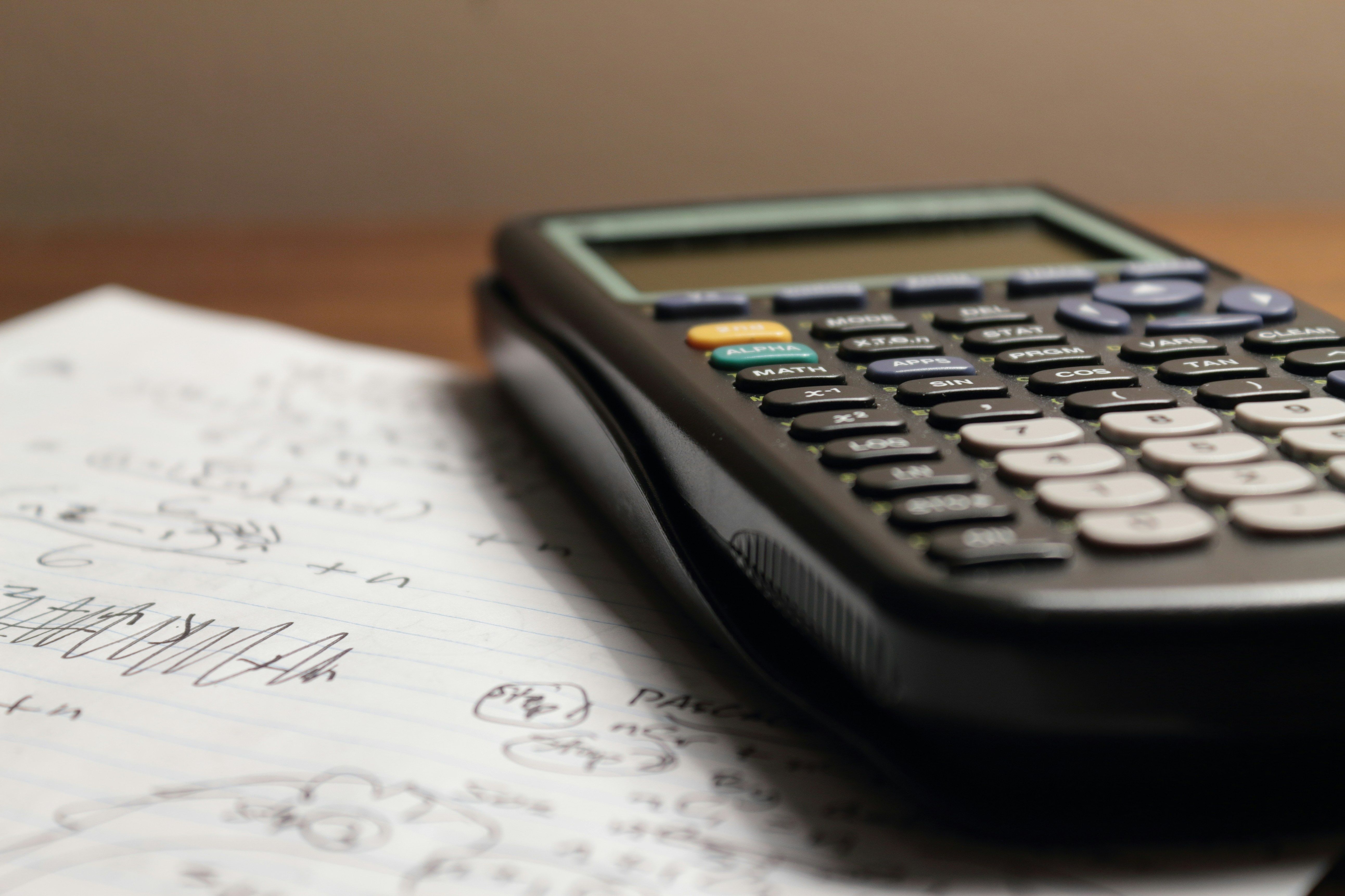 a calculator is sitting on top of a piece of paper drafting a business case.
