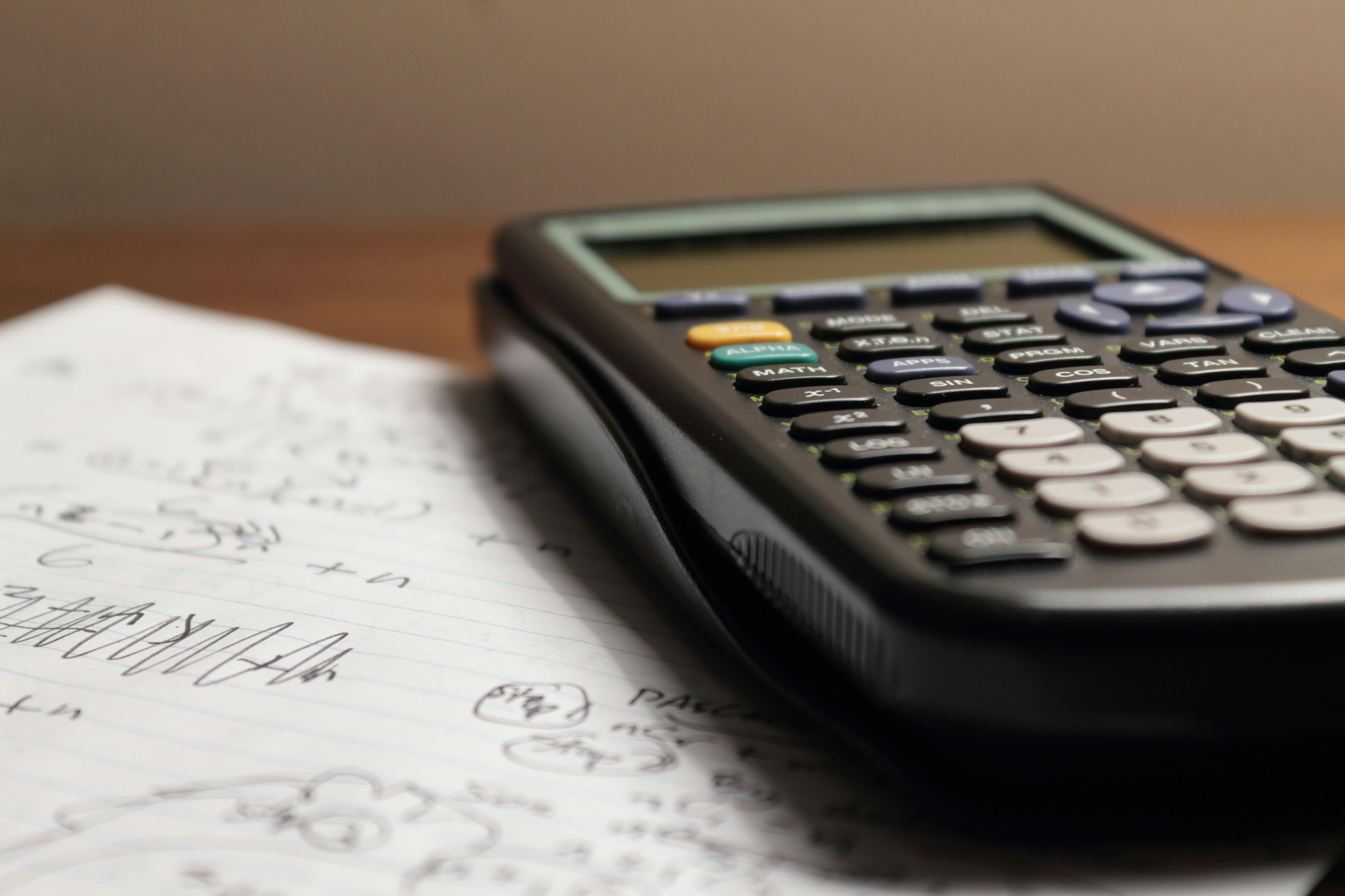 a calculator is sitting on top of a piece of paper drafting a business case.