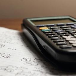 a calculator is sitting on top of a piece of paper drafting a business case.