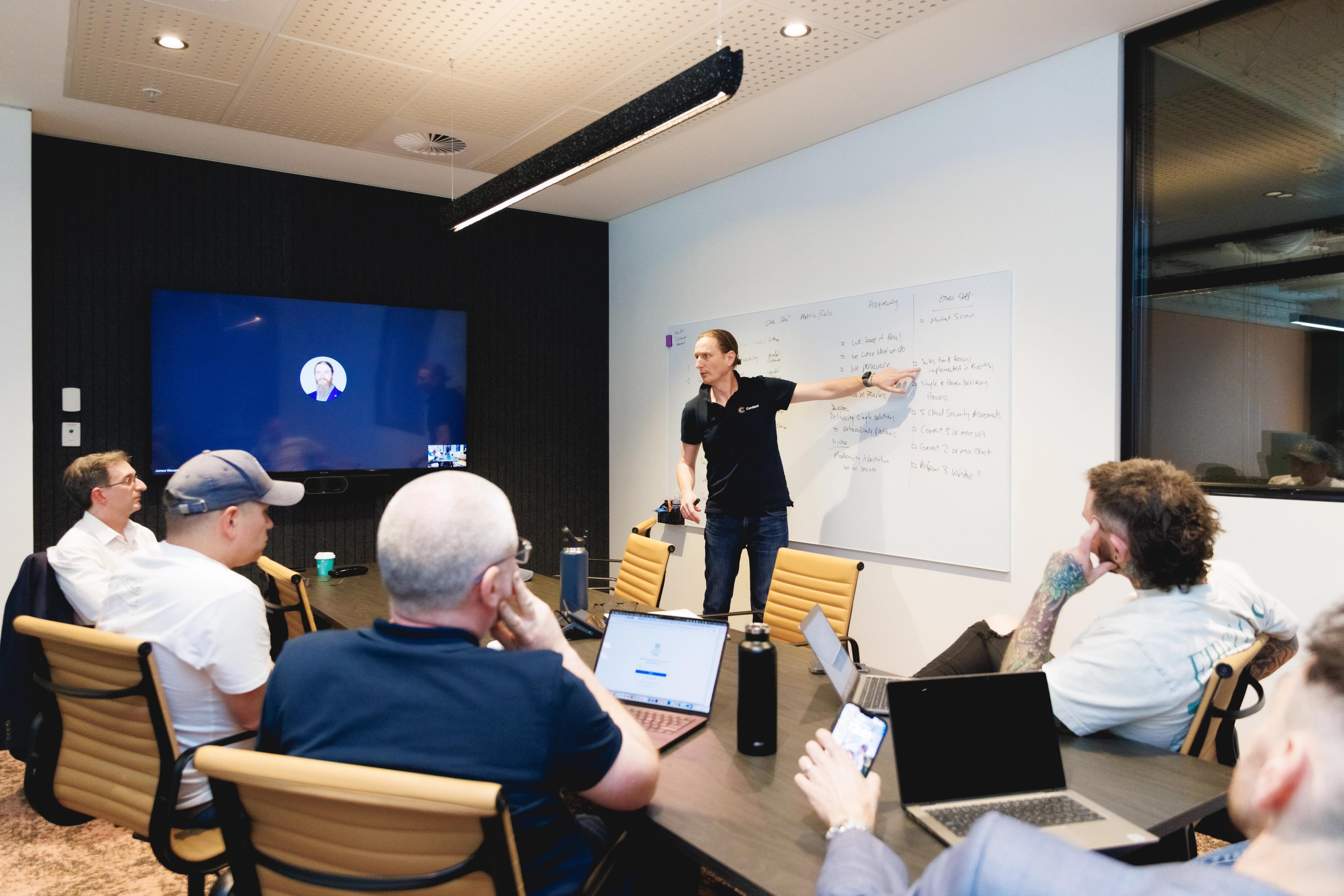 a man is giving a presentation to a group of people in a conference room .